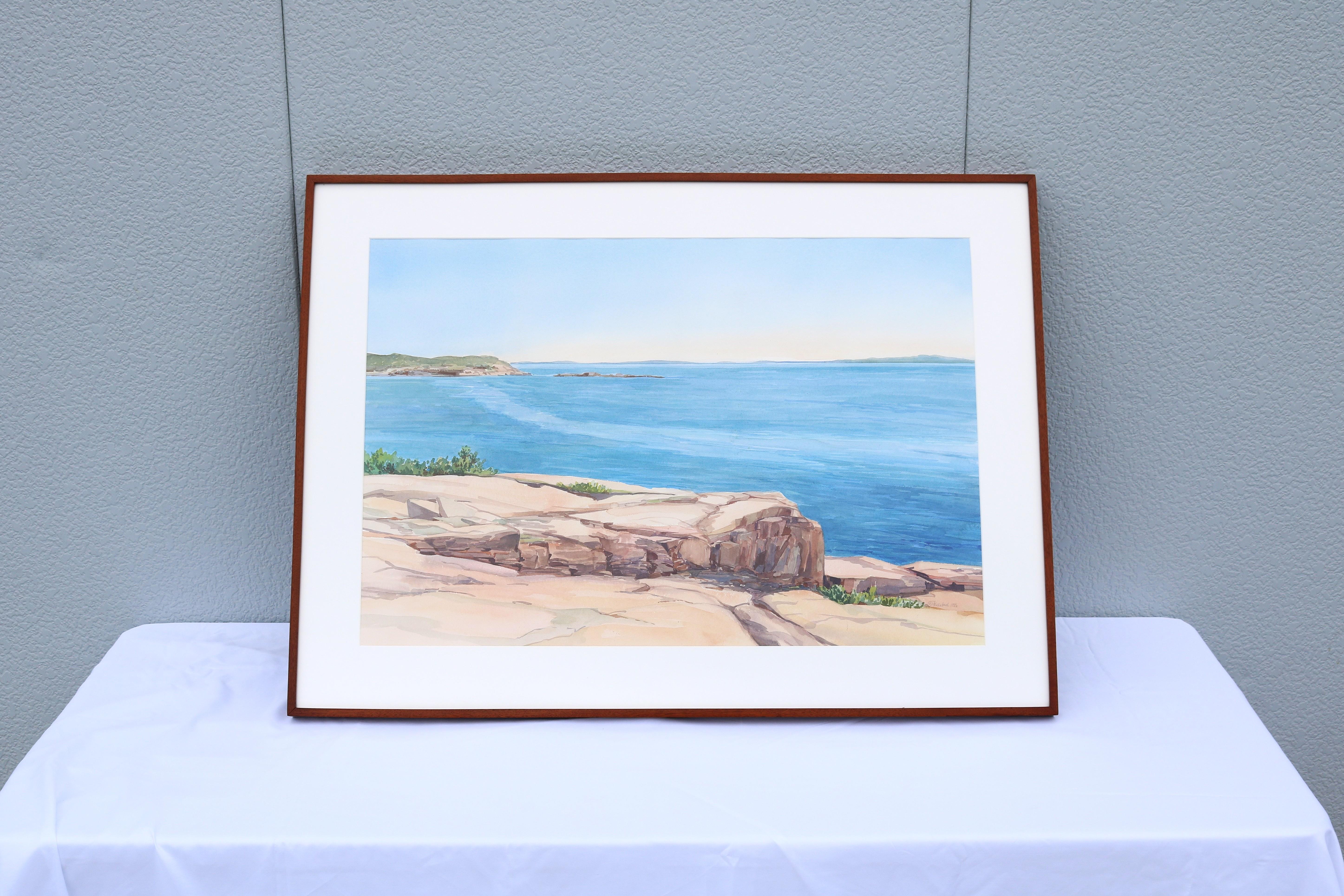 Fabelhaftes, 1986 von Hannah Ferenbach geschaffenes, gerahmtes Aquarell einer felsigen Küstenlandschaft auf Papier. Signiert und datiert vom Künstler unten rechts.
Das Gemälde zeigt eine in Sonnenlicht getauchte Küstenlandschaft mit einem felsigen