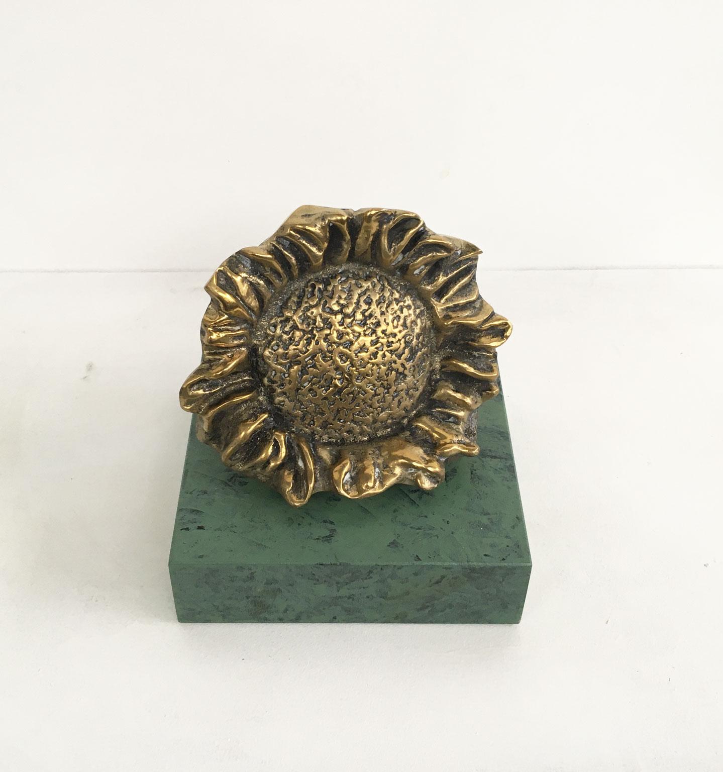 This is an engaging bronze sculpture created by the Italian artist Patrizia Guerresi, in 1986. The piece is a multiple of 1000 specimens on a green-painted wooden base. The title is 