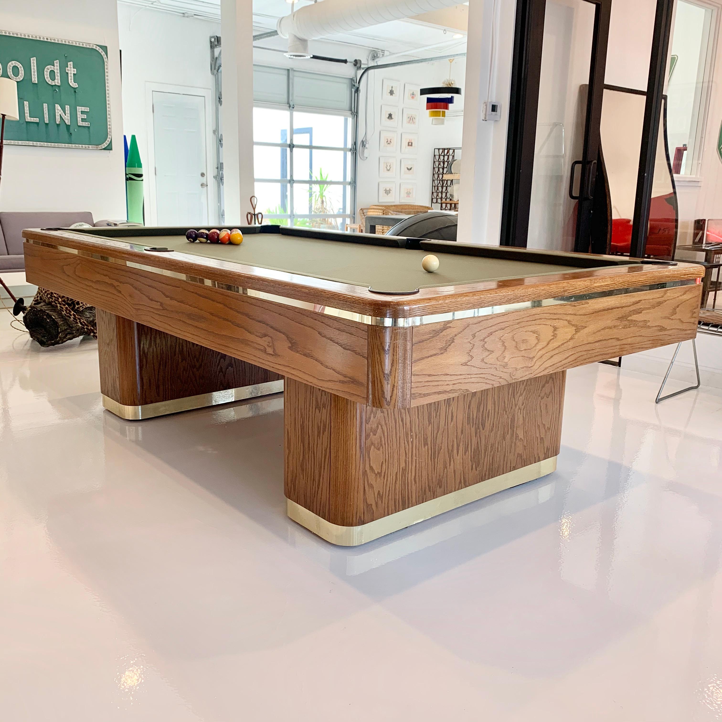Elegant oak and brass POOL table made in Los Angeles, California. Dated 11-4-86. Good condition with some wear to wood and brass. New bumpers and new olive tournament felt. 8-foot table. 3-piece slate underneath. Custom made back in the 1980s.