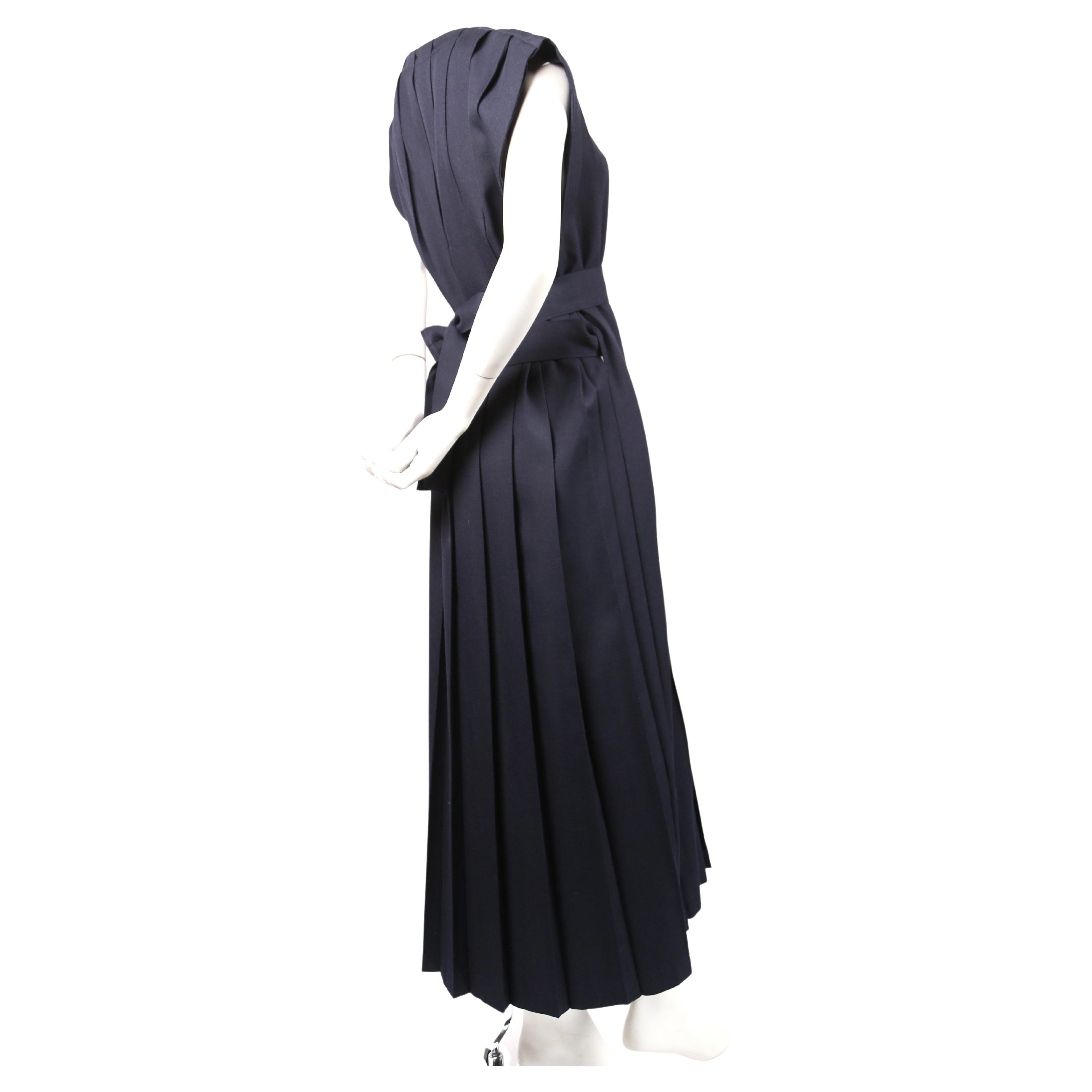 Very rare, navy-blue wool dress with box pleats and long waist tie designed by Rei Kawakubo of Comme des Garcons dating to fall of 1996. No size indicated. Best fits a S or M. Width is adjustable. Approximate length 52