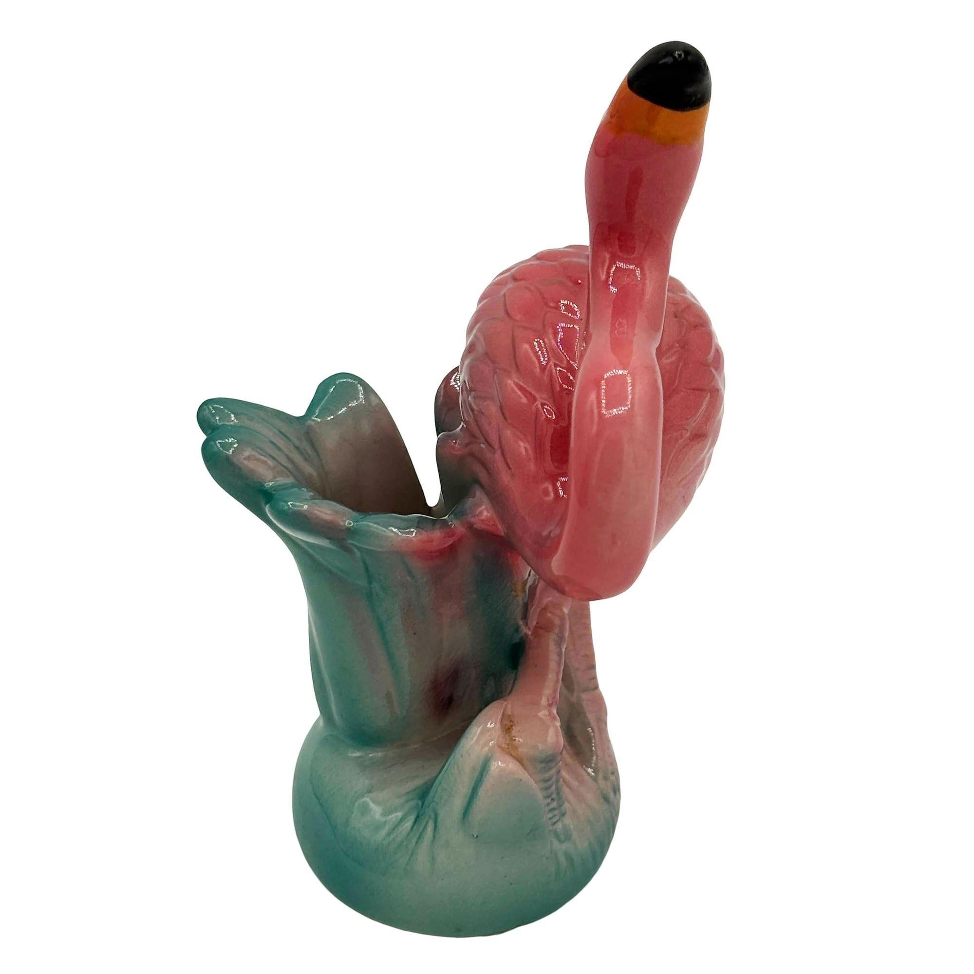 Salière de table flamant rose et vert en céramique du milieu du siècle par Five & Dime. Le shaker présente des flamants roses détaillés dans des feuilles vertes luxuriantes et de l'herbe de couleur rose.

En bas, on peut lire : 