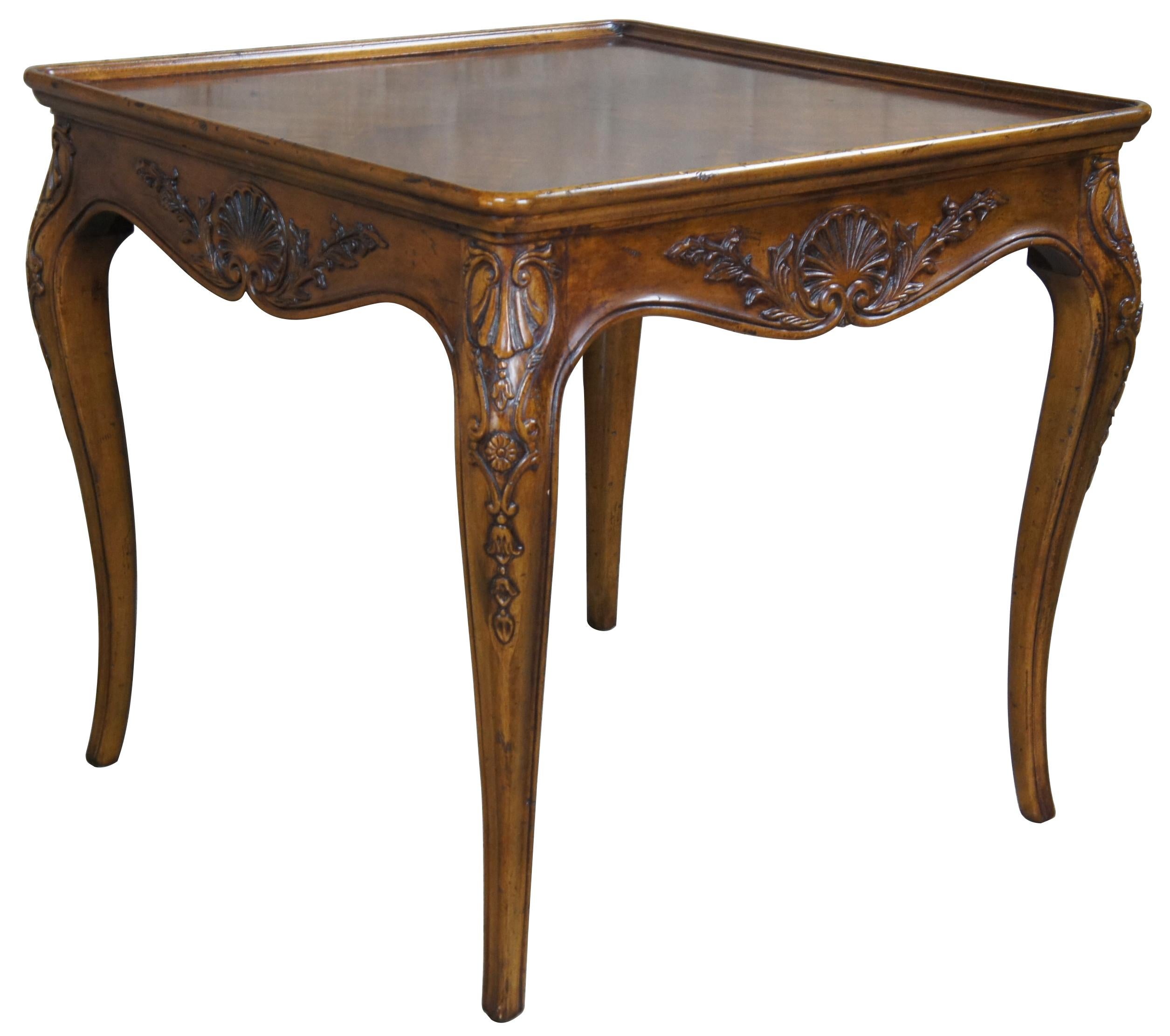 Henredon French Country side table, circa 1986. Made from walnut with an inset bookmatched walnut top over a carved and scalloped arpon. The tables are supported by cabriole legs with shell and cartouche carvings. Style No 3201-42.
 