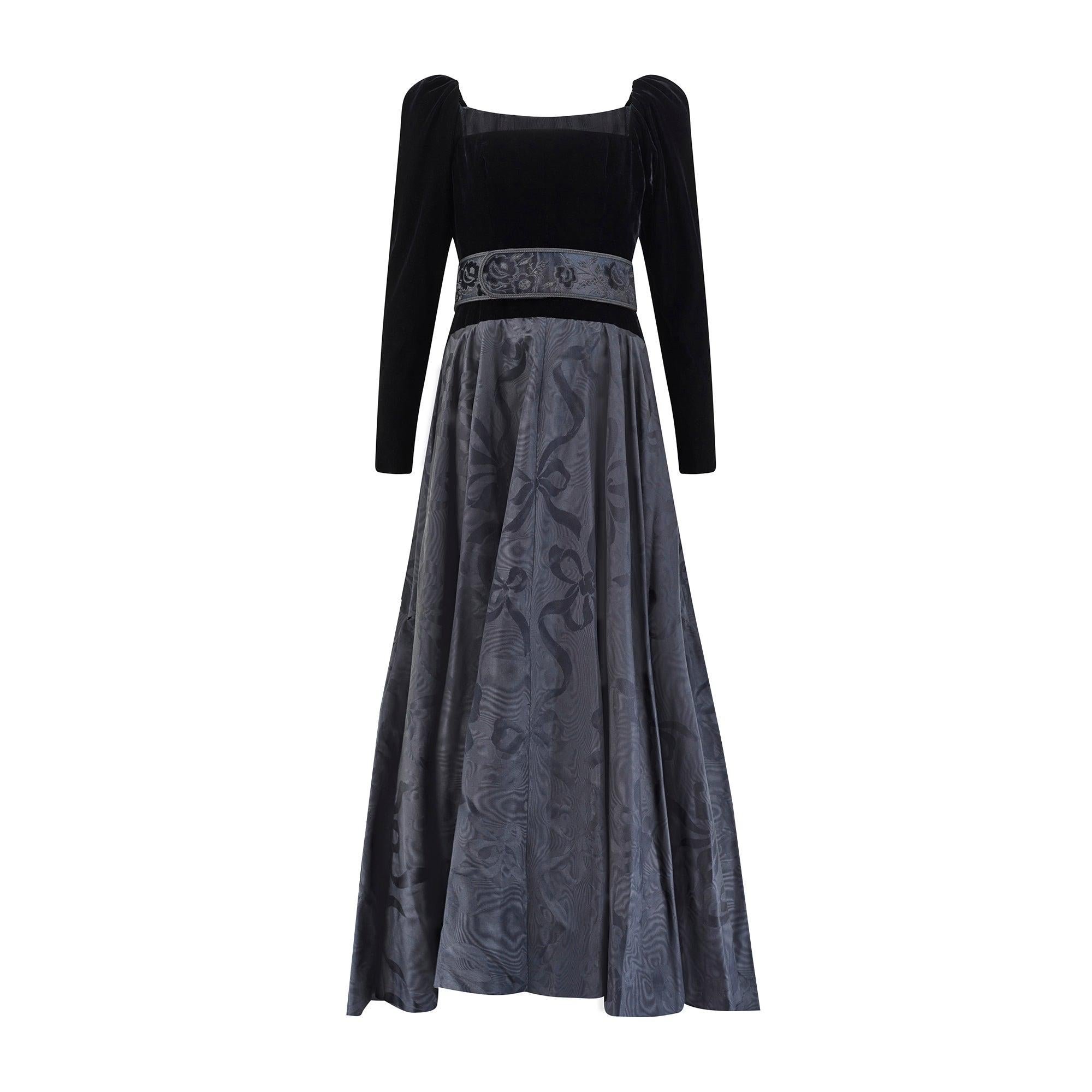 This black evening dress was commissioned by a special client from Yves Saint Laurent’s 1986 haute couture runway collection. The fabric is a shimmering black moiré jacquard silk woven with tonal motifs of bows and swirling ribbons that appear to