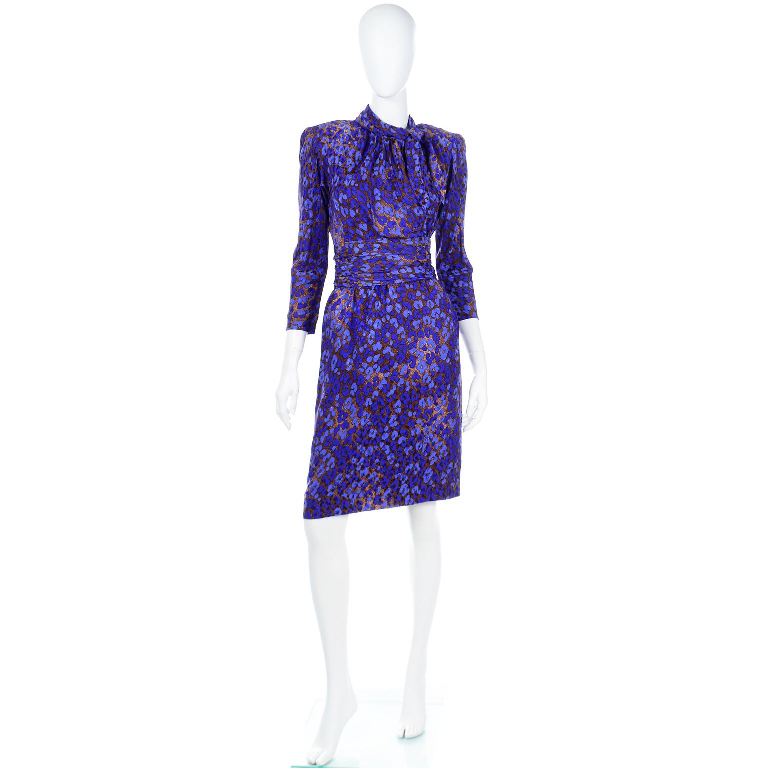 This Yves Saint Laurent 1986 runway documented vintage faux wrap style dress is in a saturated royal blue and copper brown leopard print silk. The skirt portion of the dress is fully lined and there are removable shoulder pads. The dress closes with