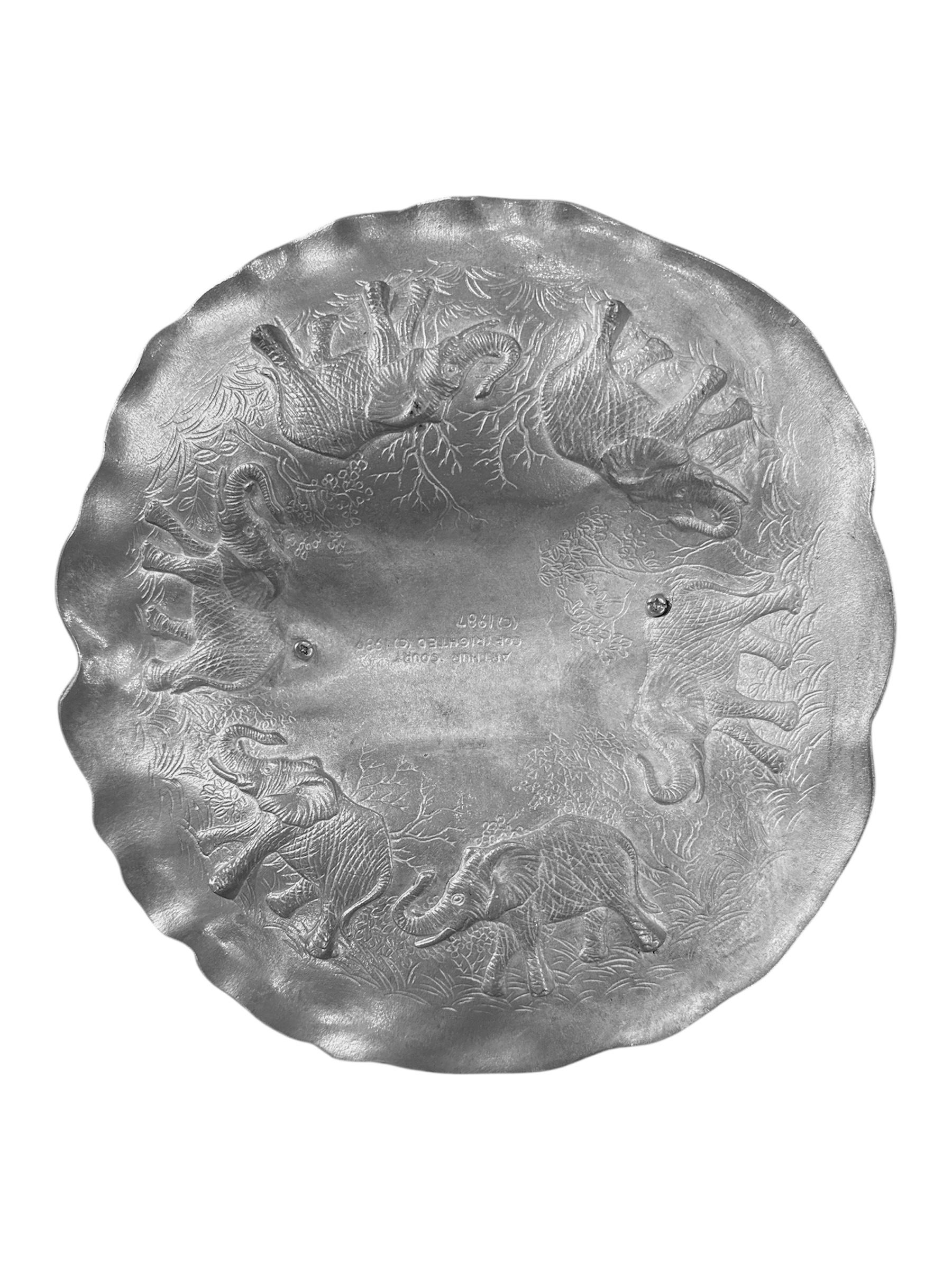 Faites une déclaration audacieuse avec ce plat à éléphant Arthur Court vintage de 1987, une pièce d'art fonctionnelle étonnante qui capture l'esprit de la nature. Moulée de manière experte dans l'alliage d'aluminium emblématique d'Arthur Court,