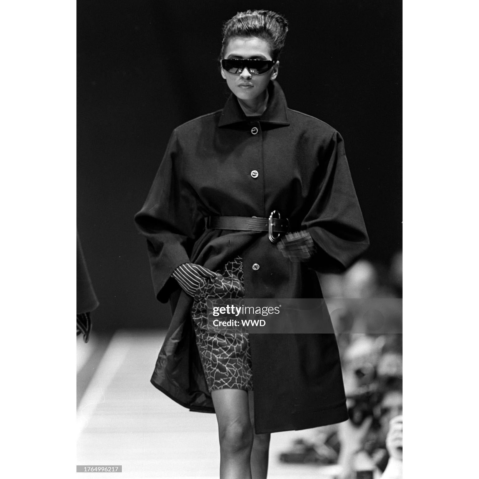 This sublime vintage black wool coat is from the F/W 1986 Gianni Versace runway collection. The model on the runway is wearing the coat with the top button buttoned and a different belt. This luxurious, sophisticated coat comes with a beautiful