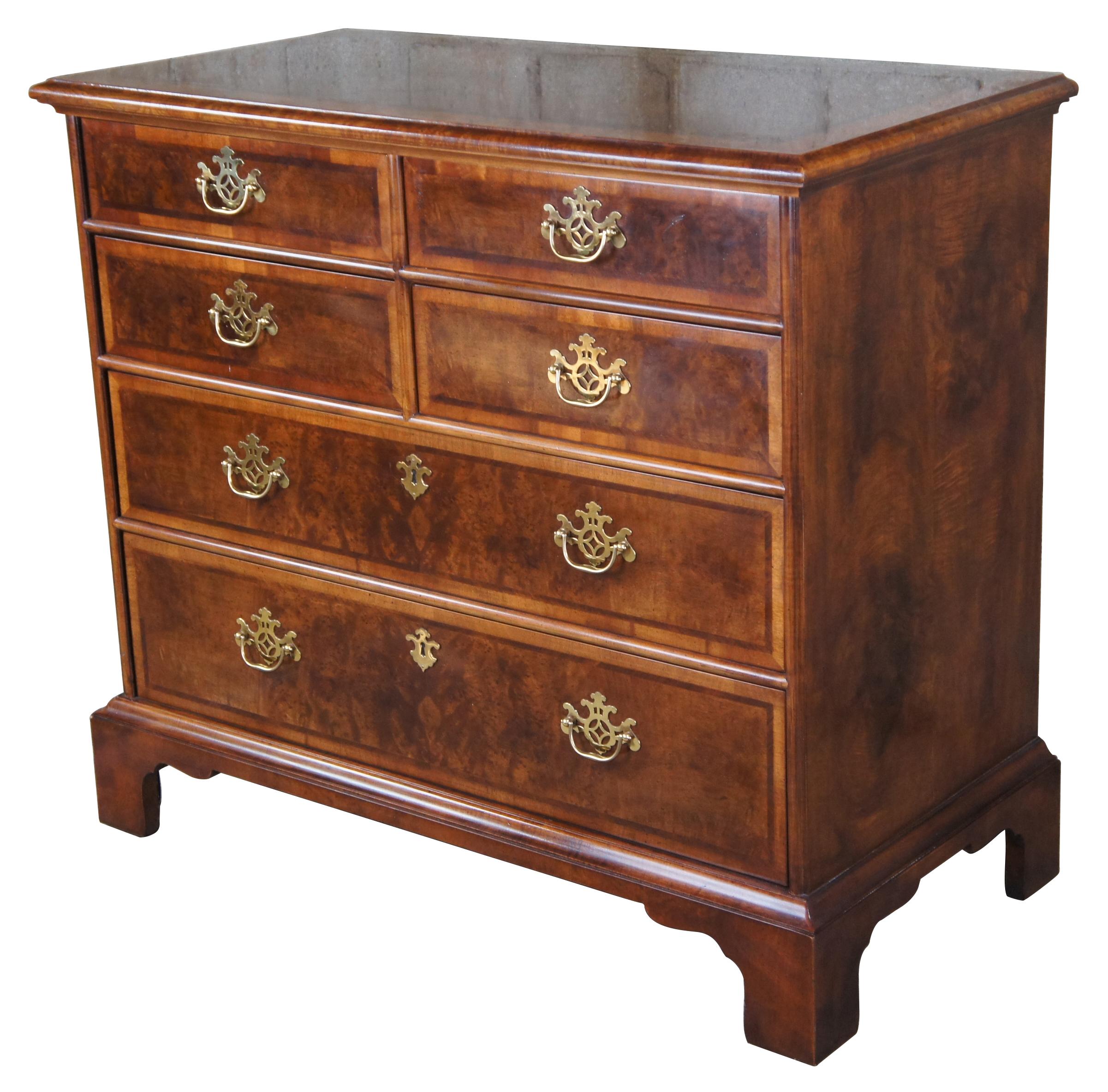 Henredon Aston Court chest of drawers. Model 9700-02, circa 1987. Made from Olive burl and banded mahogany. Features four over two dovetailed drawers with brass hardware. The chest is supported by bracket feet. Draws inspiration from Chippendale and
