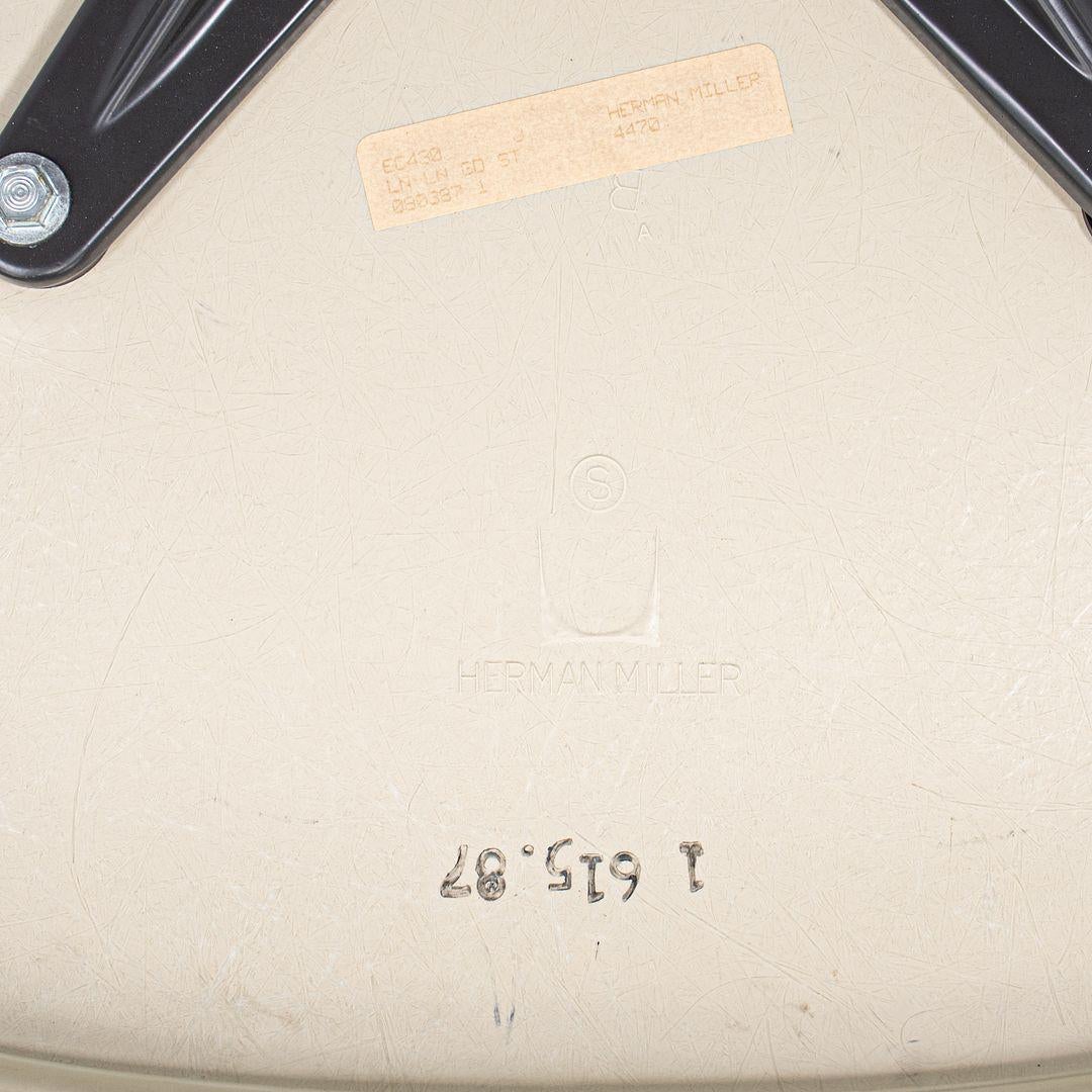 This is an EC430 chair, originally designed by Ray and Charles Eames in the 1970s. This particular example was produced by Herman Miller in the USA C. 1987. The chair is comprised of a fiberglass shell seat with foam with blue hopsack upholstery