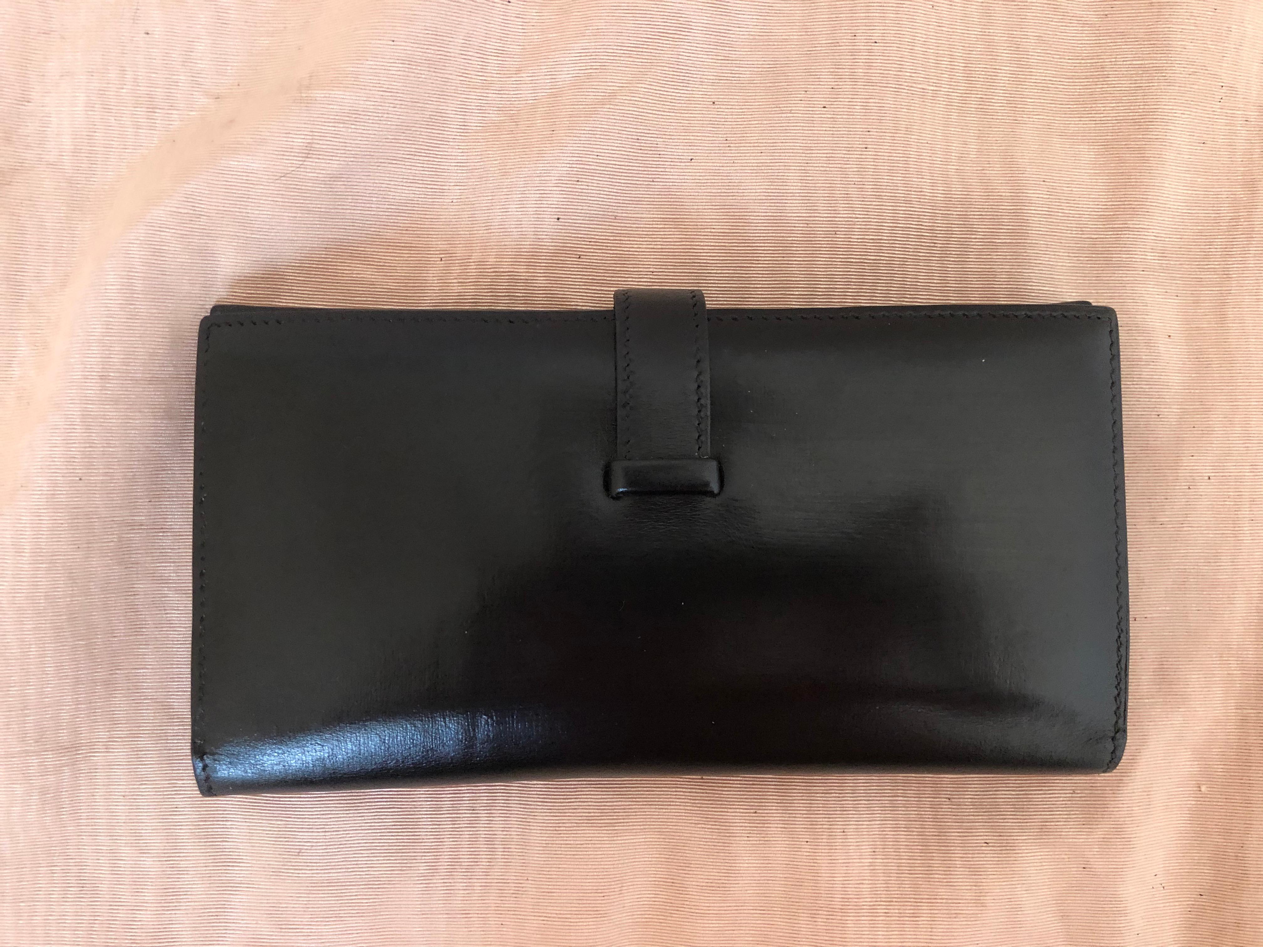 This Hermes Bearn Wallet is constructed of smooth leather with gold hardware. It has a front band closure; five card slots; two flat pockets; a zipper compartment, and two bill pockets.

I have marked it as in good condition as the zip pocket flap