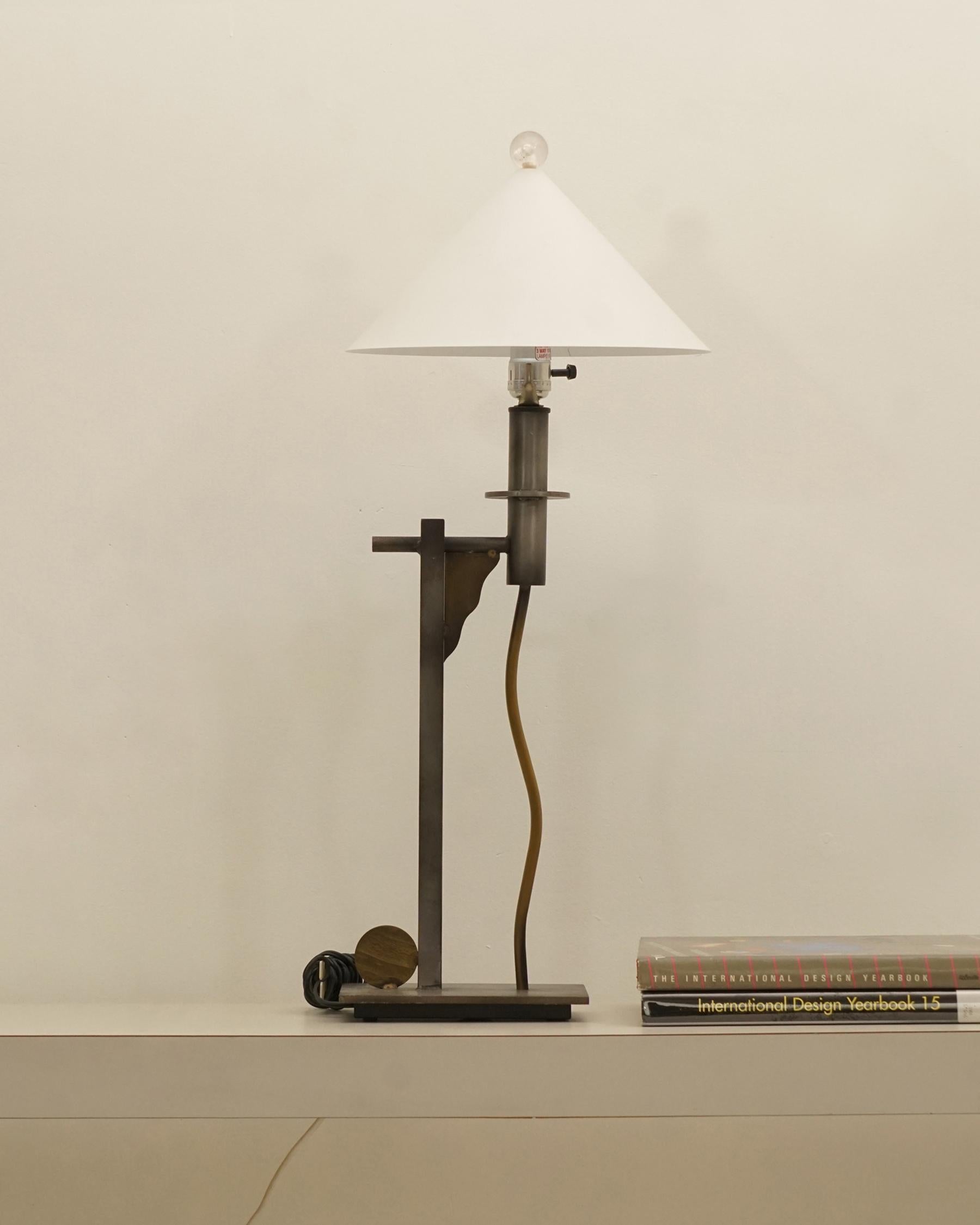 1980s Postmodern, Memphis lamp by Robert Sonneman for Geroge Kovacs. Metal conde shade base with contrasting gunmetal and brass shapes and finishes. Acrylic finial. Shade a replacement and not an original. In excellent and works well. Overall wear