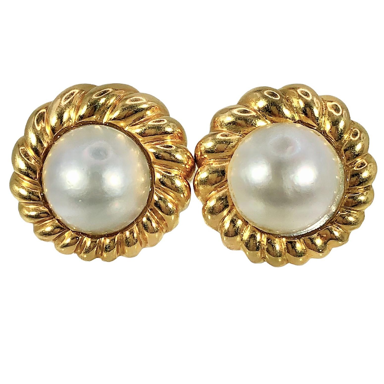 This traditional pair of Tiffany & Co. 18K gold and Mabe pearl earrings are truly classic and tasteful. The Light Cream Rose color Mabe Pearl centers are surrounded by a  bold, rope border. Measures a maximum diameter of 7/8 inch. Equipped with