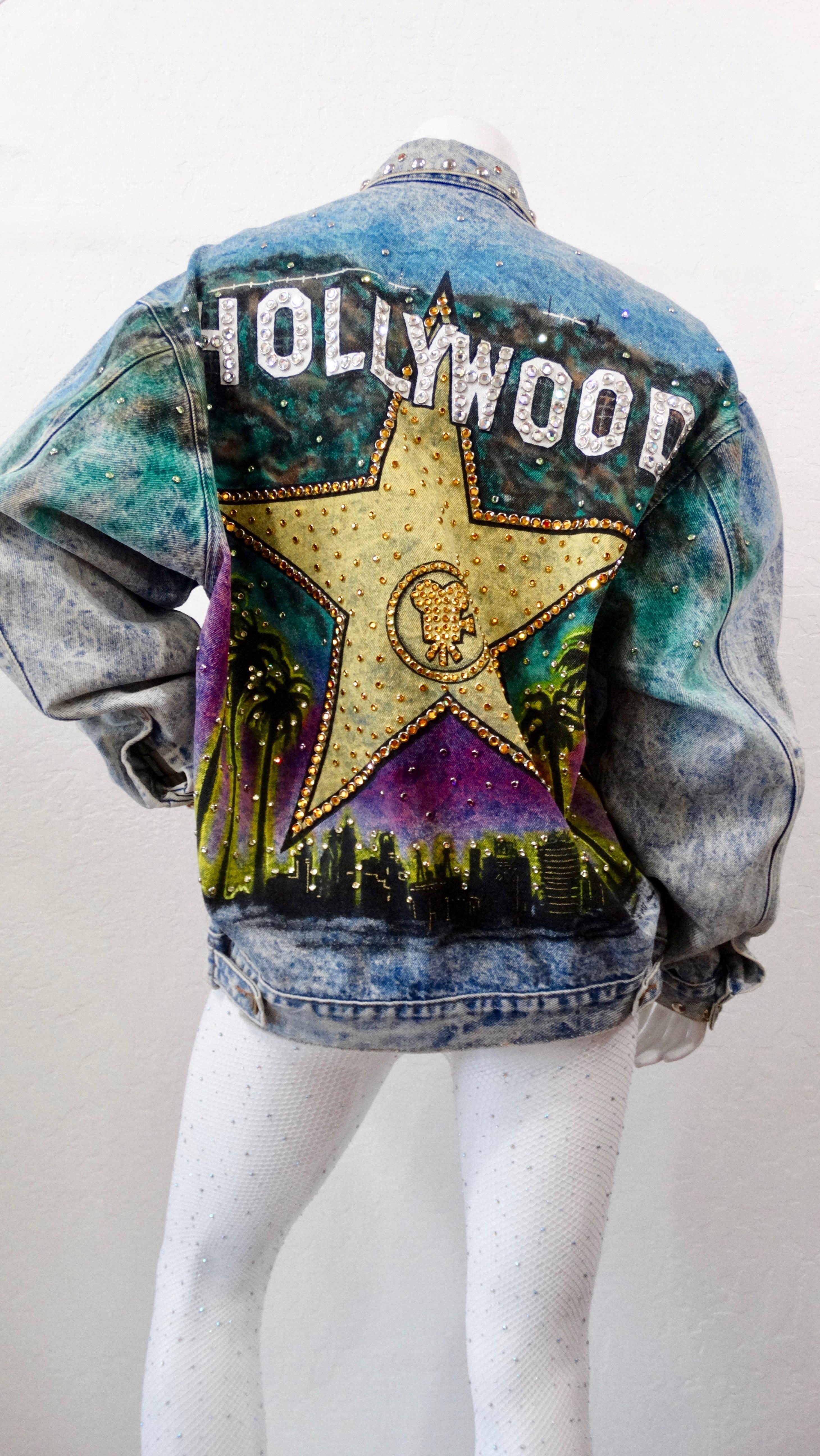 Feel like the ultimate Hollywood star with this Tony Alamo jean jacket! Circa 1987, this oversized jean jacket features an acid wash, brass toned buttons, two front pockets and eye-catching rhinestone embellishing throughout. The front of the jacket