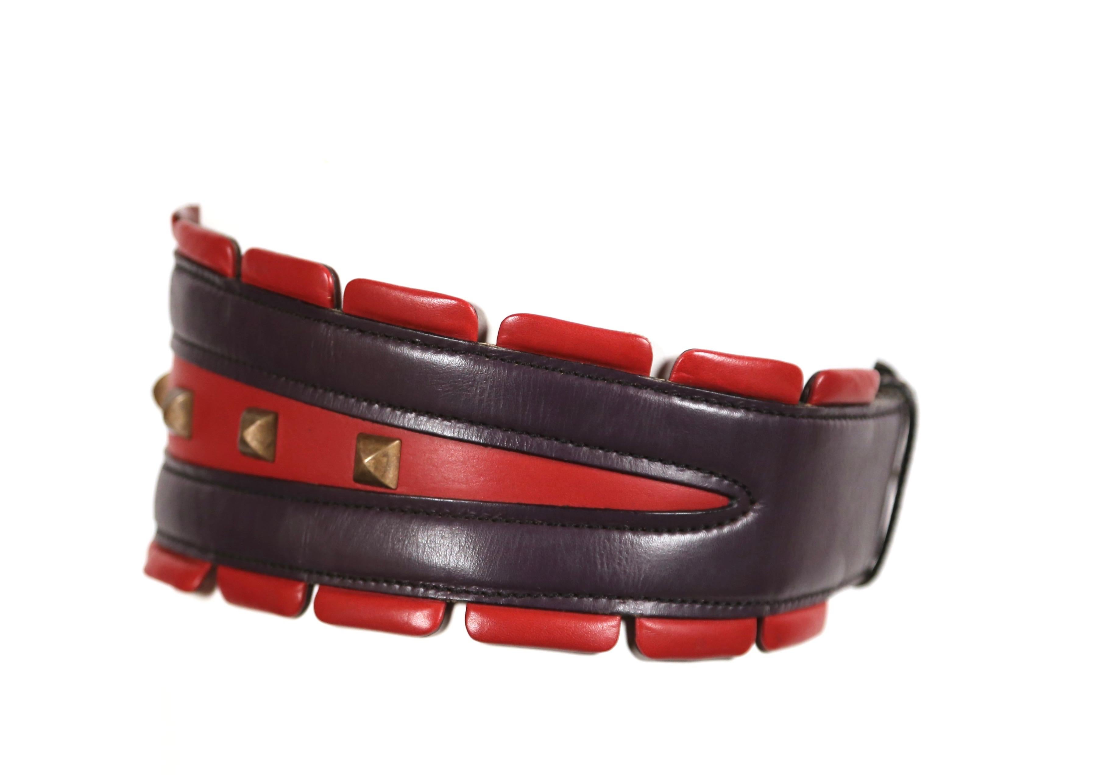 Très rare, ceinture en cuir rouge et violet avec clous pyramidaux en laiton conçue par Azzedine Alaia comme vue sur le défilé de l'automne 1988. La ceinture est étiquetée 65 français et convient idéalement à une taille de 23-25