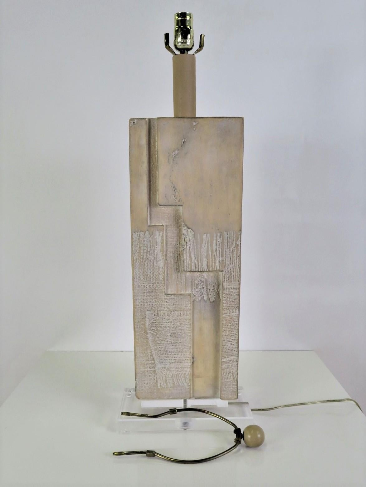 Raised on a lucite rectangular plinth base, this 1980s Lamp has a Brutalist Shaped stacked Stone Slab Form center.  Made by Casual Lamps of California, incorporating their favorite look of whitewashed forms.  Original wiring and new three level UL