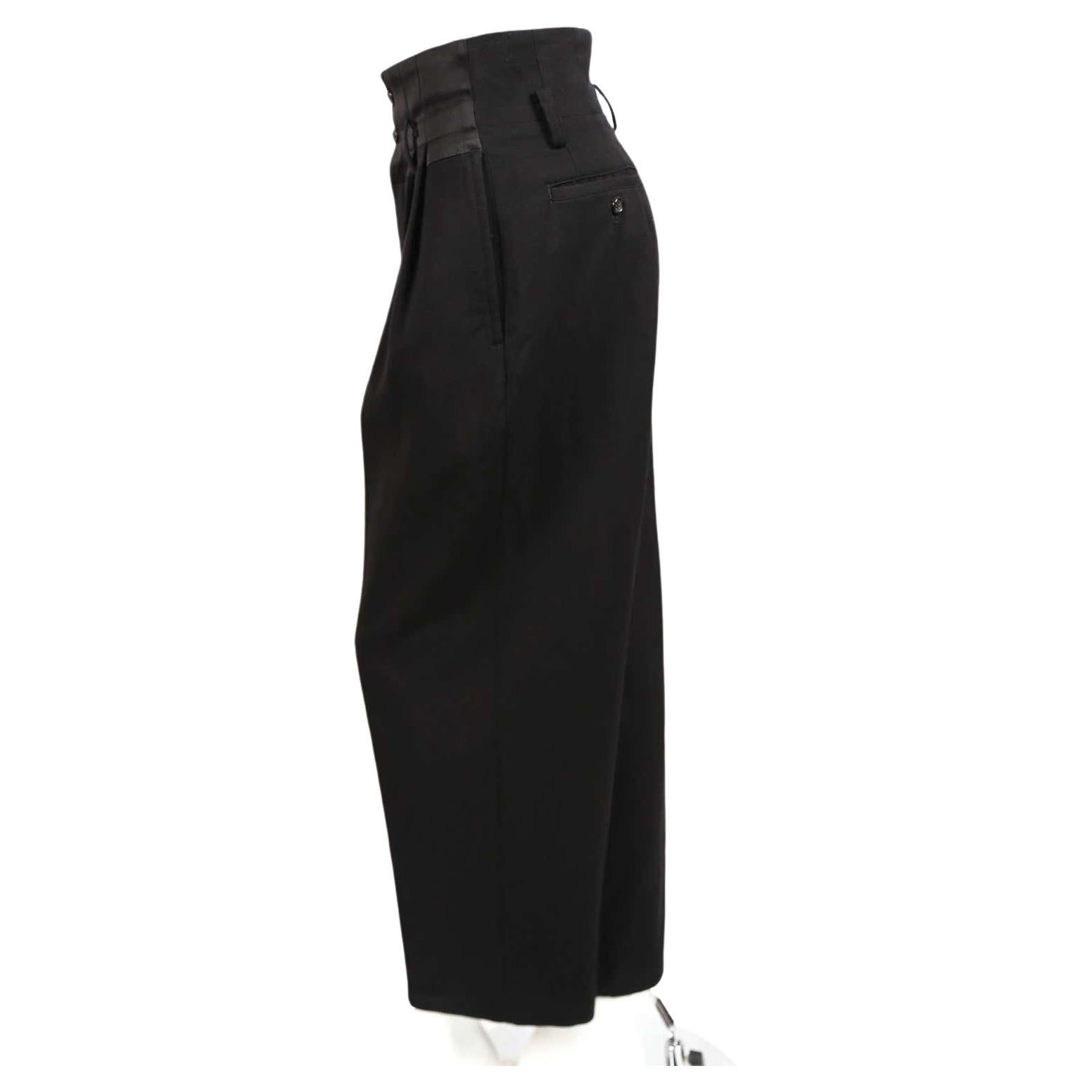 Jet-black, pleated, wool pants with silk satin waistband designed by Rei Kawakubo for Comme Des Garcons dating to 1988. Size 'S'. Approximate measurements: width of waistband at top 28