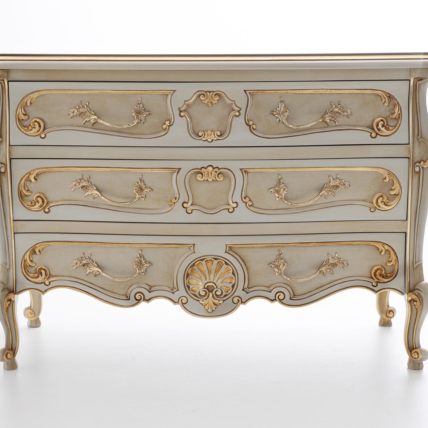 The epitome of classic style, this dresser is crafted of solid wood and features three spacious drawers with wooden runners. Dainty carvings executed by hand adorn the legs and drawers' front, the bright brass handles flaunting a precious gold