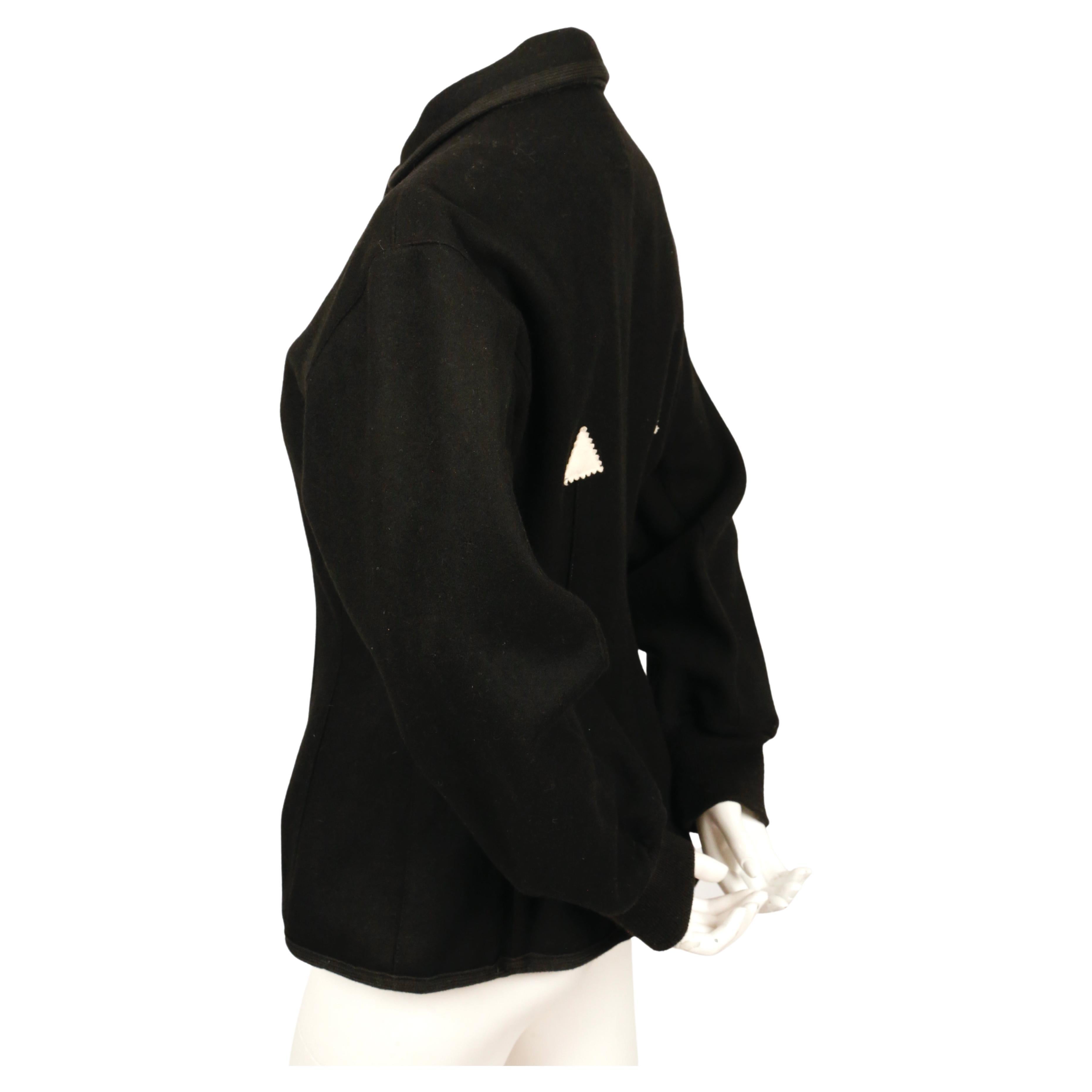 Schwarze Korsettjacke aus gefilzter Wolle mit schwarzen Paspeln, gerippten Ärmelbündchen und cremefarbenen Zickzack-Dreiecken von Jean Paul Gaultier Junior aus dem Jahr 1988, wie sie auf dem Laufsteg im Herbst 1988 zu sehen war. Etikett mit der
