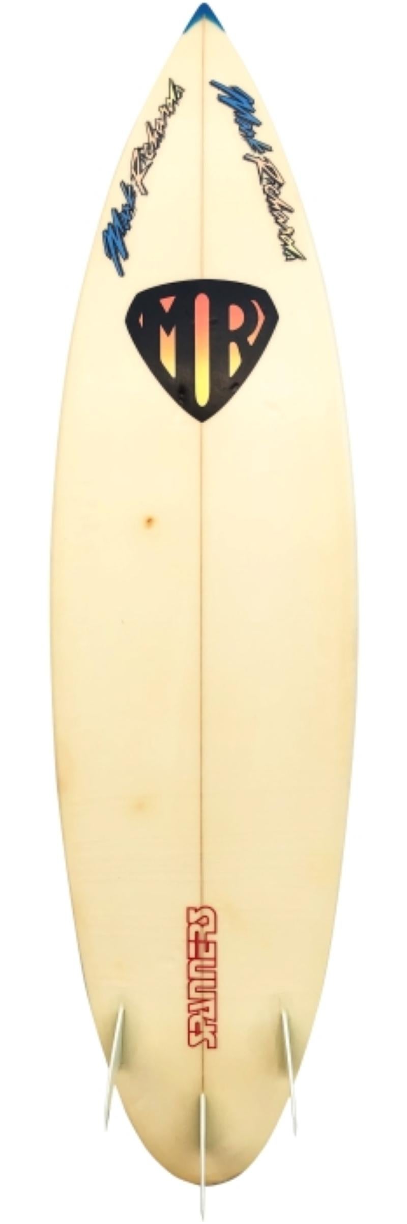1988 Mark Richards (MR) surfboard. Features 80s style colorful Mark Richards text and iconic MR Superman logos. Rounded pintail shape design with glassed on thruster (tri-fin) setup. A very clean example of a 1980s surfboard shaped under the premier