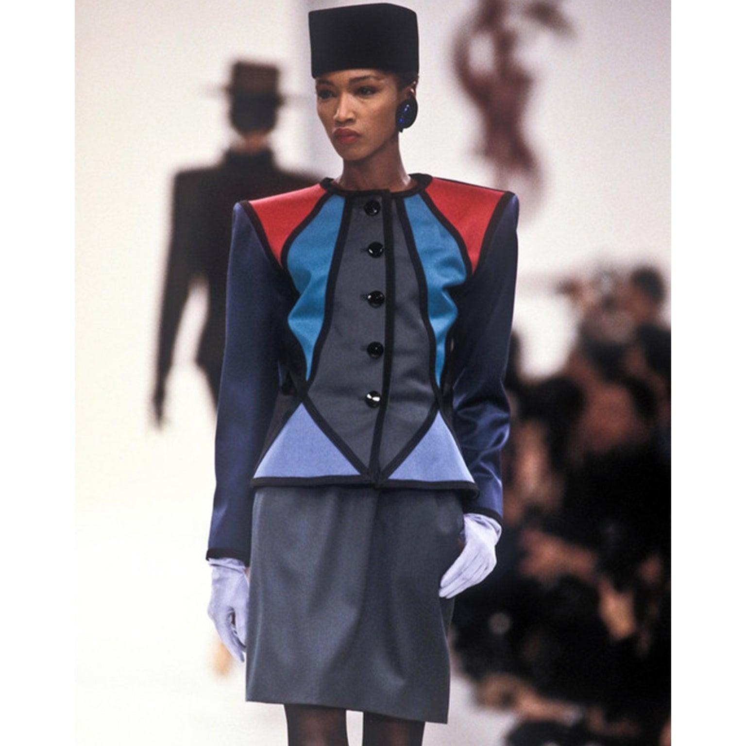 This is an iconic vintage Yves Saint Laurent Rive Gauche jewel tone color block jacket and skirt suit. This fabulous vintage wool suit was look 23 in Saint Laurent's famous Autumn/Winter 1988/89 runway show.

The boxy, collarless blazer style jacket