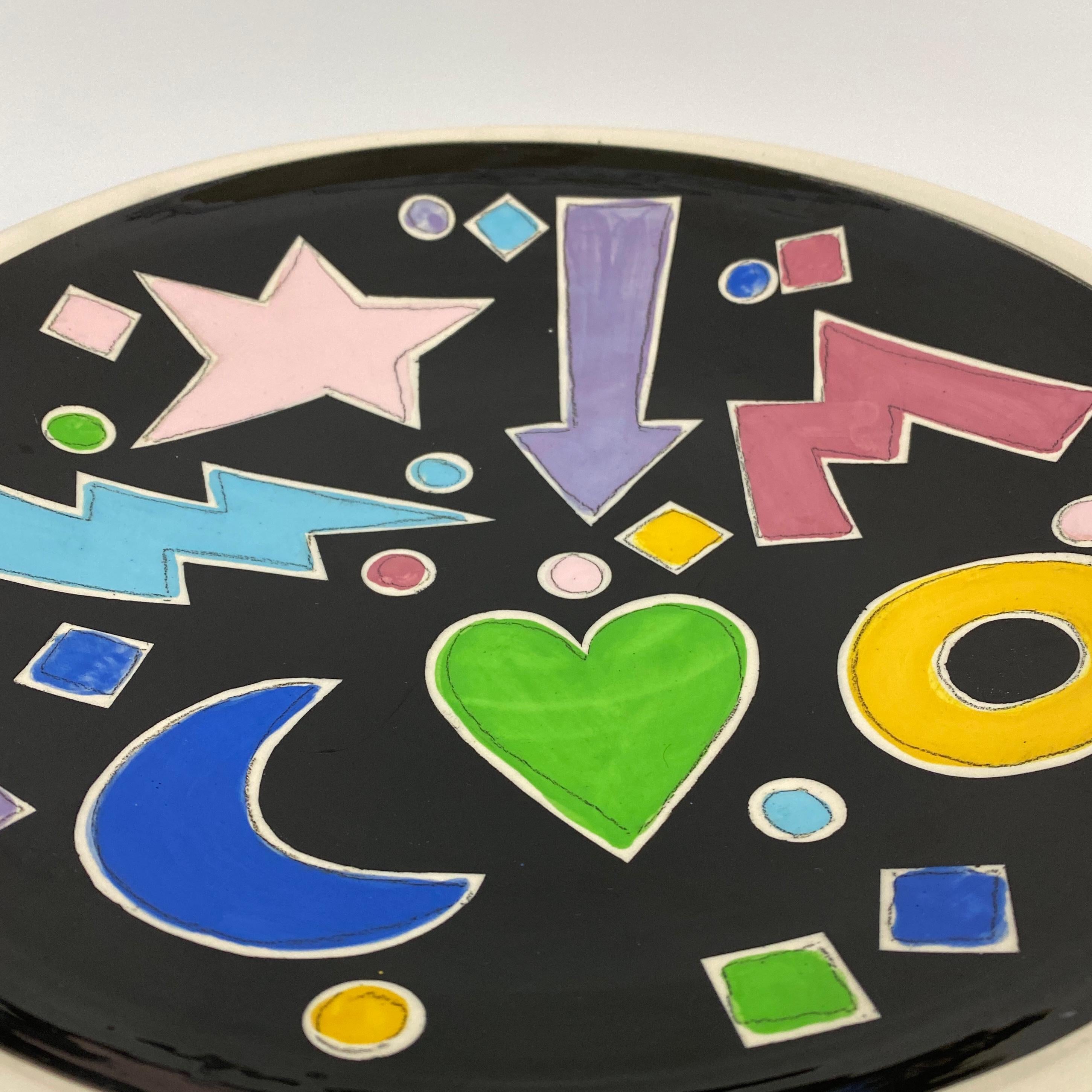 Vintage studio pottery dish with bold colors and shapes including a star, a heart, a lightening bolt and a moon. Postmodern/Pop Art design with multiple colors. Nice large scale for a statement piece of decor. Signed “T Saito 1988”.