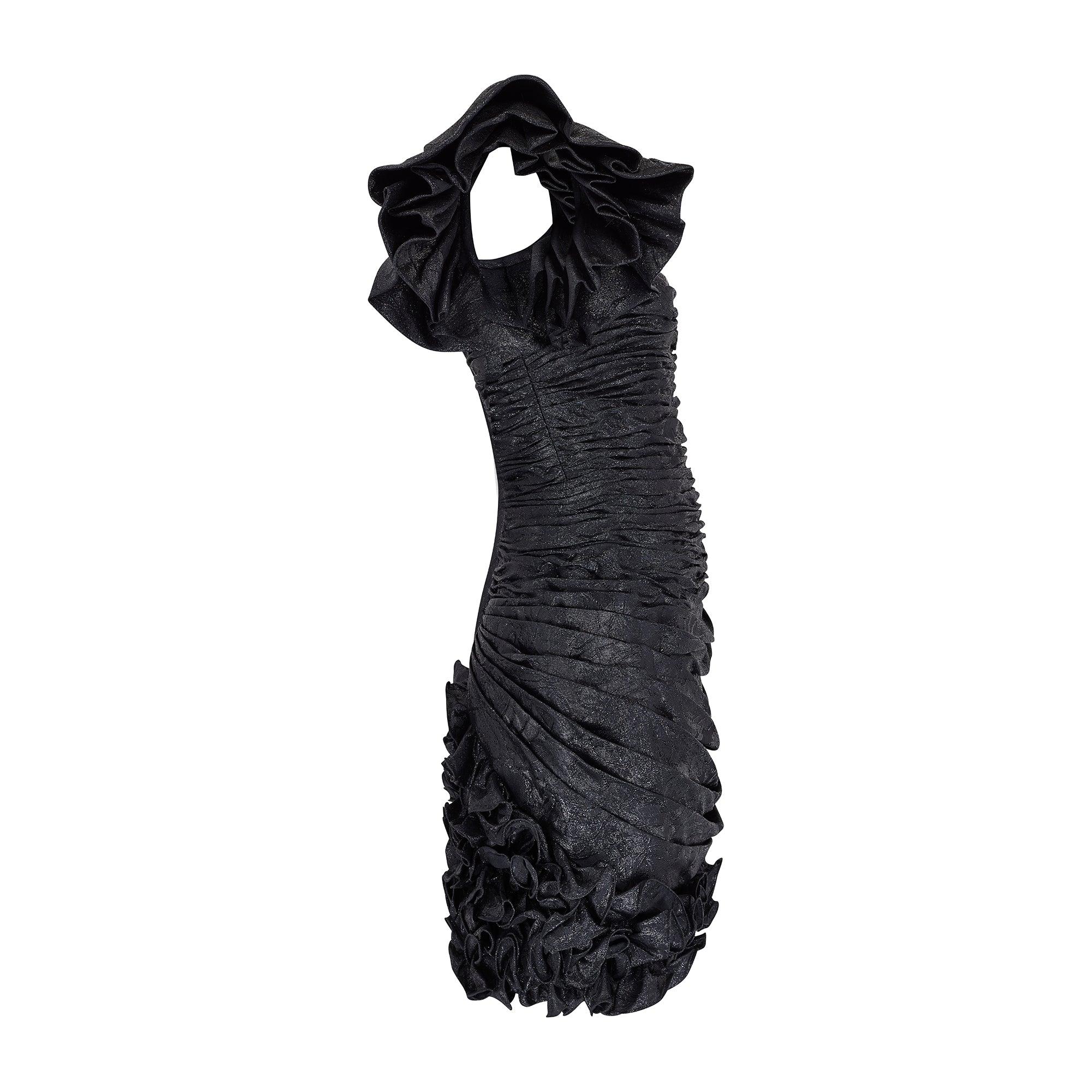 This black runway documented 1980s lame cocktail dress is by renowned French couturier Emanuel Ungaro. With a dramatic square neckline, the dress is sleeveless but with an exaggerated double layer of ruffles at the shoulders, ruched fabric wrapped