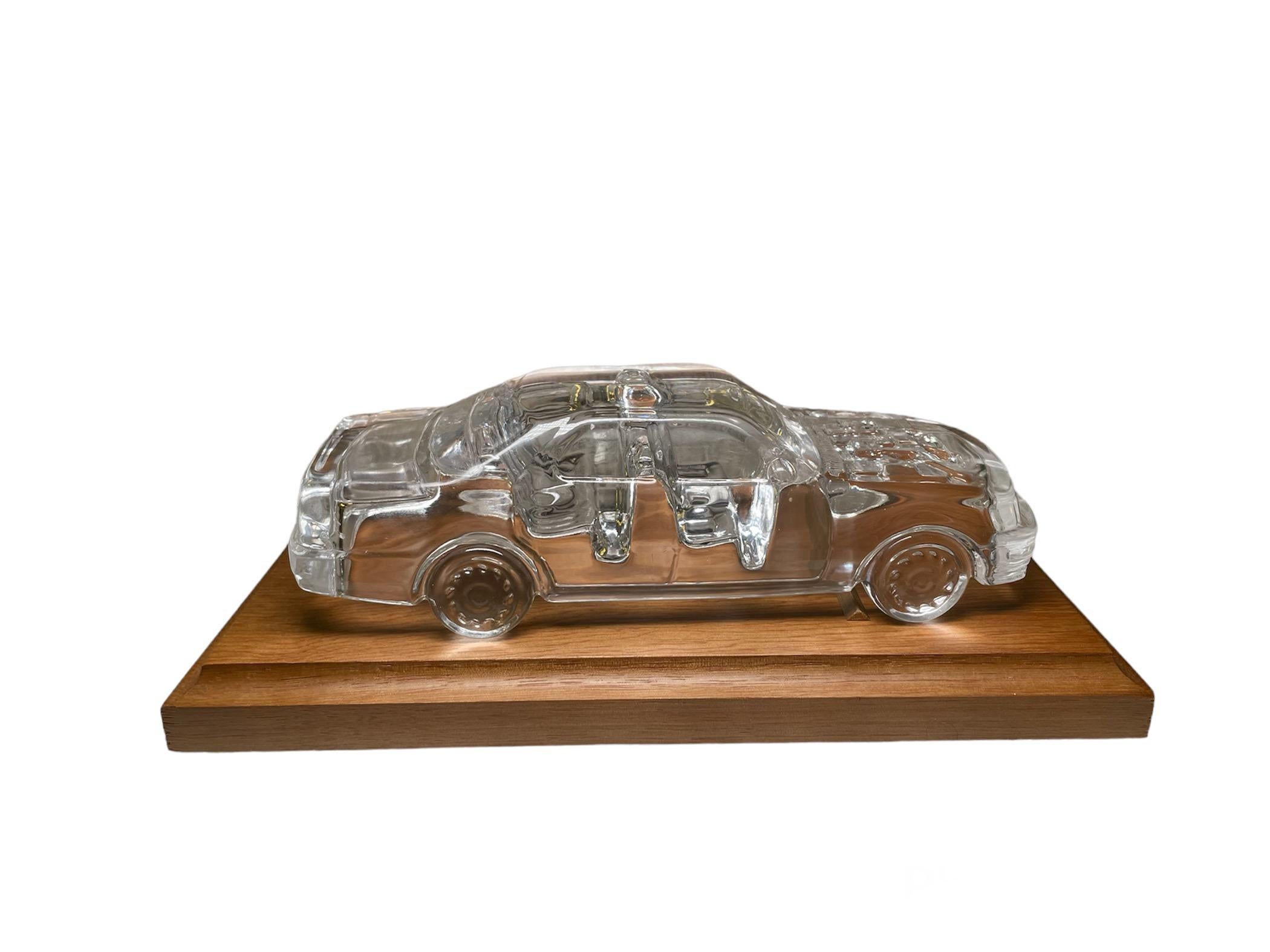 This is a clear crystal Lexus LS 400 car paperweight. Very nicely you can see through the crystal the inside details of the car, like the seats and the body. The Lexus car is standing over a rectangular wooden base that it’s dimensions are: Length