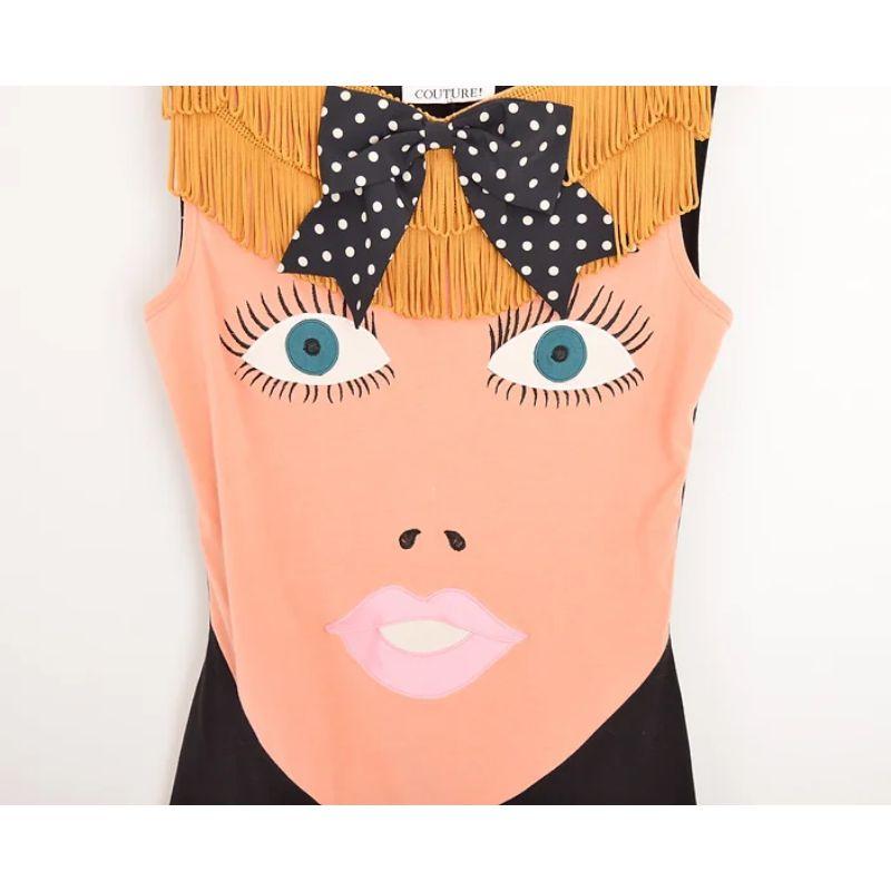 Splendide débardeur 'Blow up Doll' du défilé 1989 du label 'Moschino Couture' créé par Franco Moschino, représentant le visage d'une poupée gonflable avec des cheveux blonds frangés et un collier à nœud ludique. 

FABRIQUÉ EN ITALIE