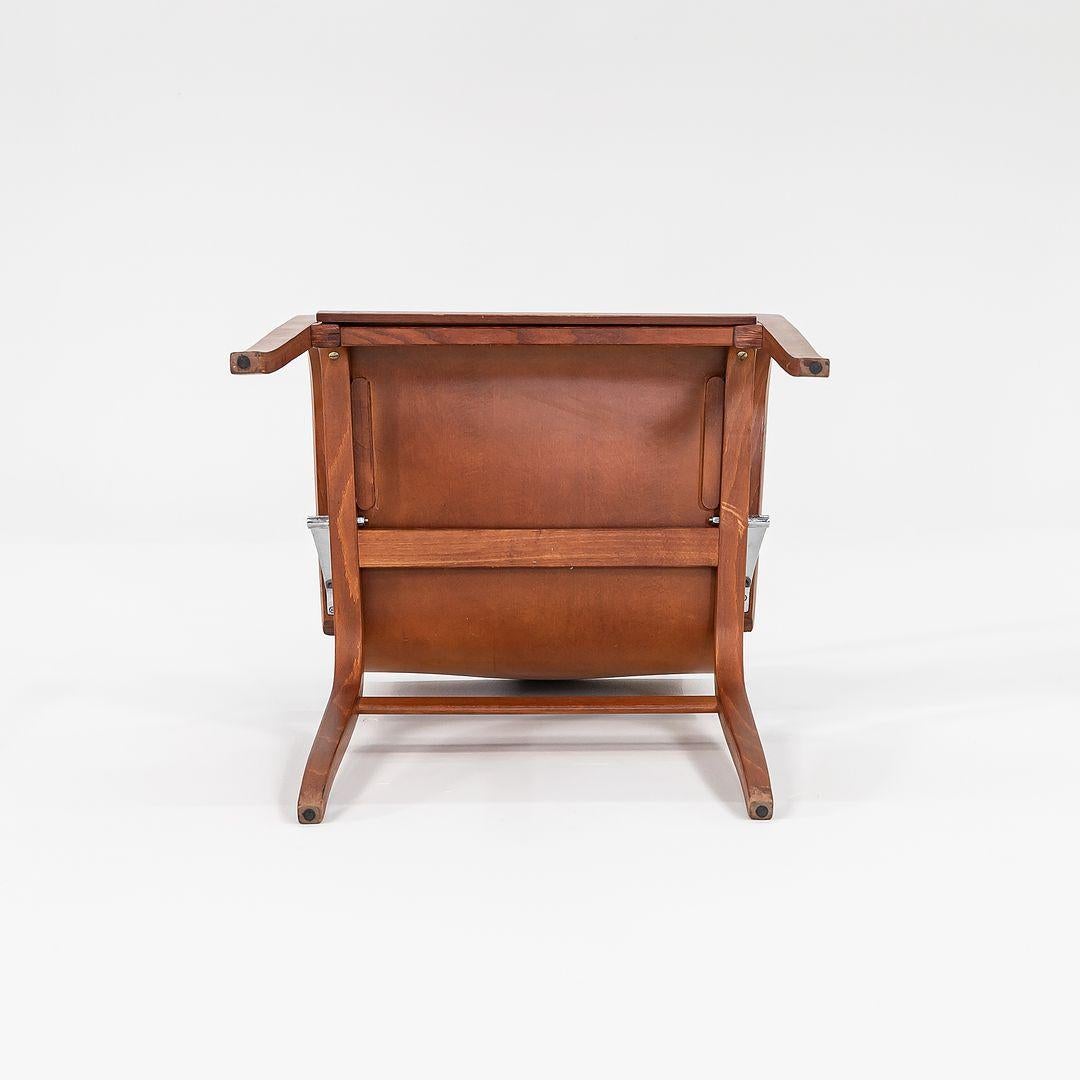 This is a Ginotta Arm Chair, designed by Enrico Franzolini for Crassevig in 1989. This piece was manufactured in Italy and imported to the USA for distribution by Knoll. Its simple sculptural design features a frame of bent plywood, and a shell in