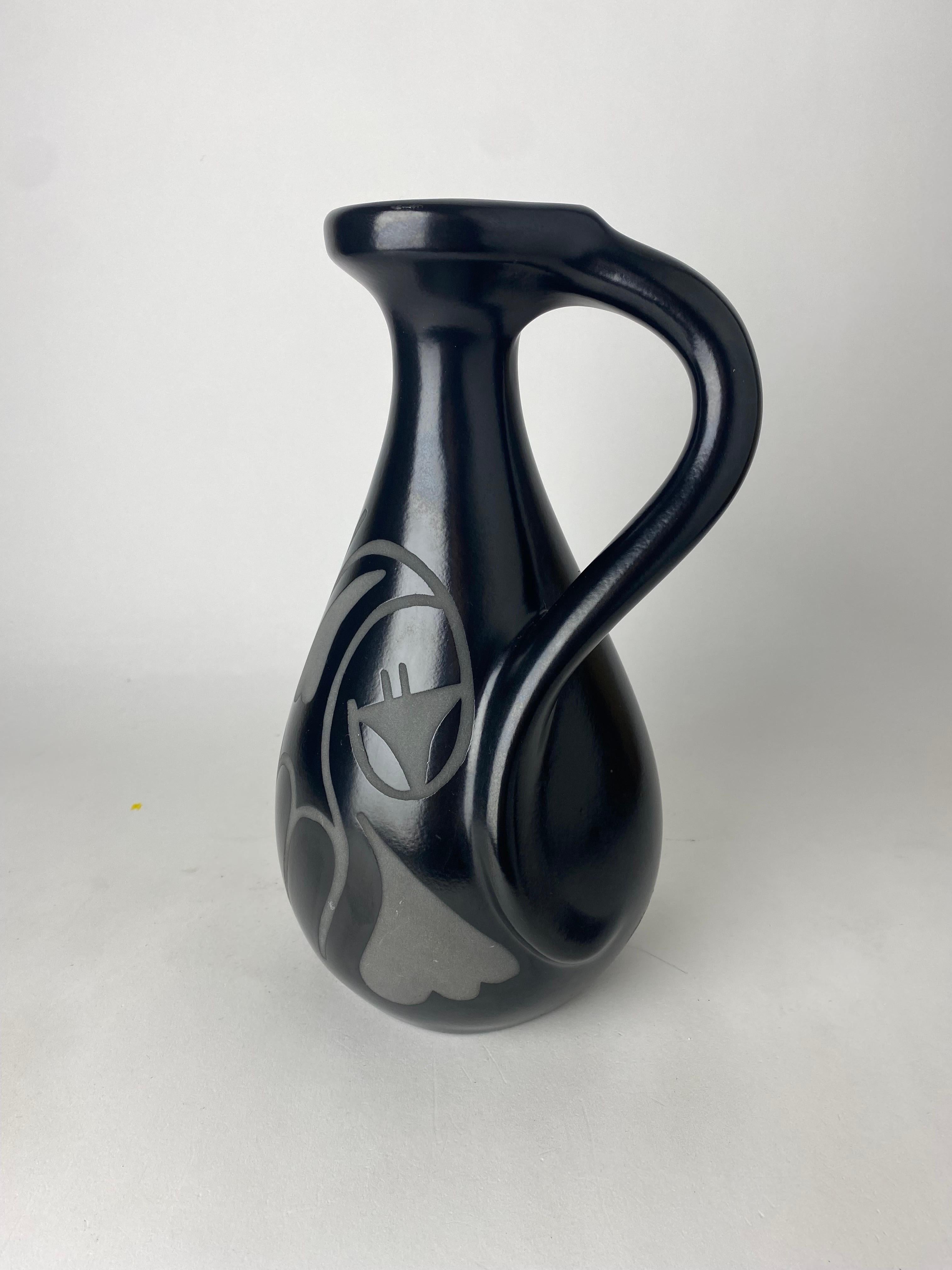 Beautiful modern design black vase with handle or pitcher and adorned with an abstract design. The vase is signed on the bottom and dated 1989. Extraordinary piece, don't miss out !


.