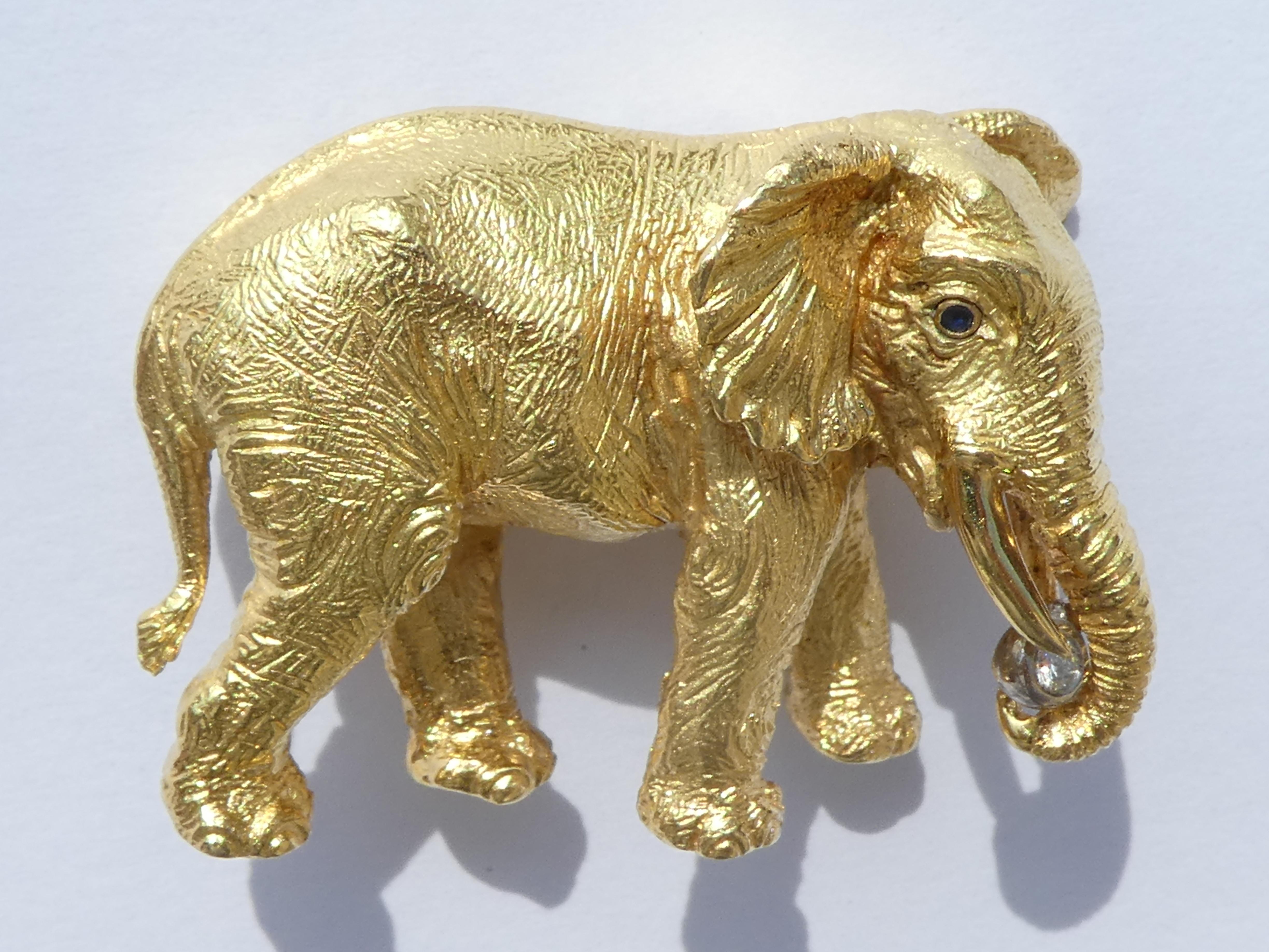 A naturalistic elephant brooch with every wrinkle of the skin beautifully visible made of 18k yellow gold (stamps: 18 k & 750) by Tiffany & Co. Germany and dated 1989 (all of this is stamped). It has 2 round blue sapphire eyes (1 in the front and 1