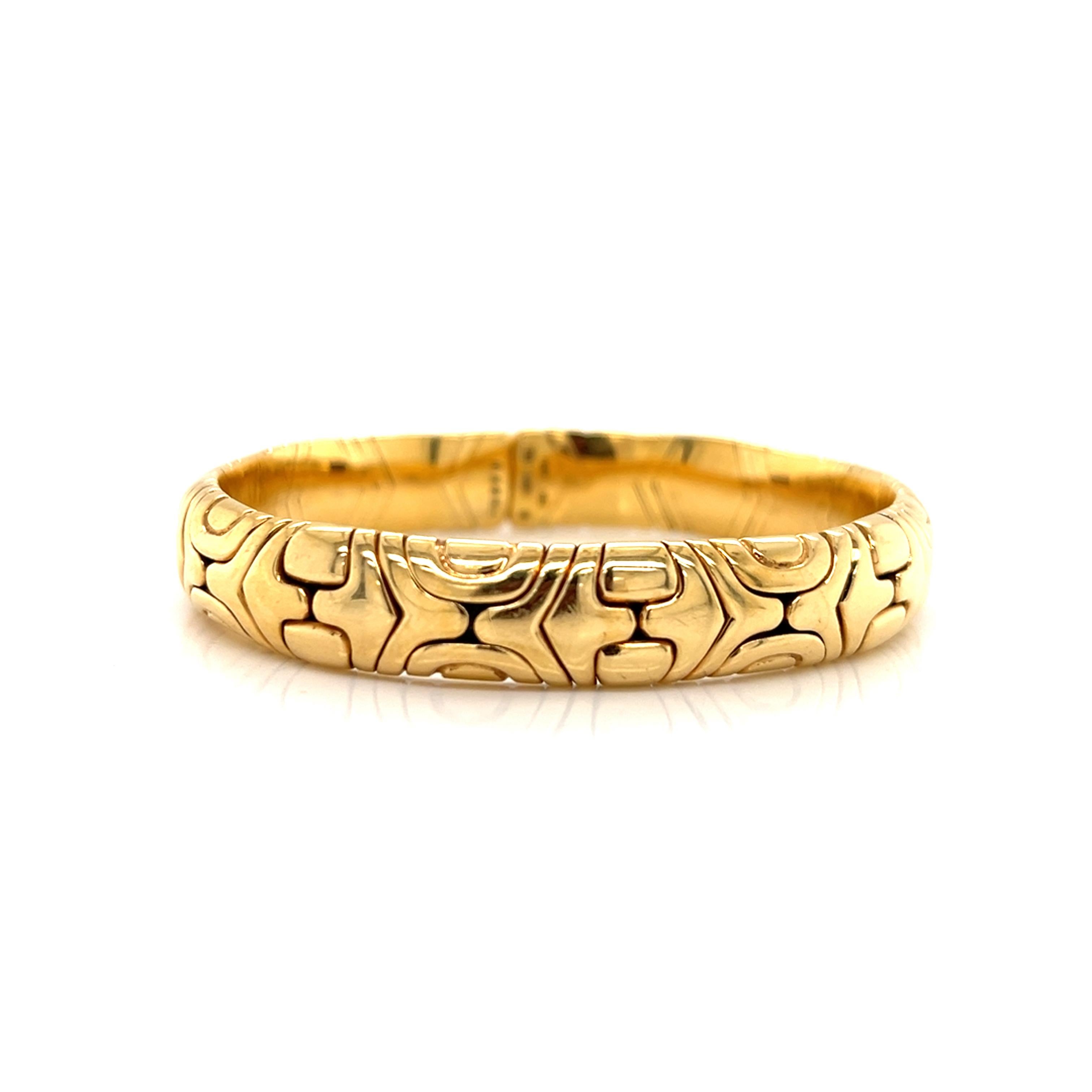 This vintage Bulgari Alveare cuff bangle is a stunning piece of fine jewelry made in solid 18-karat yellow gold. The oval shape and serpentine chain type make it a unique addition to any collection. The bracelet is signed by the designer and