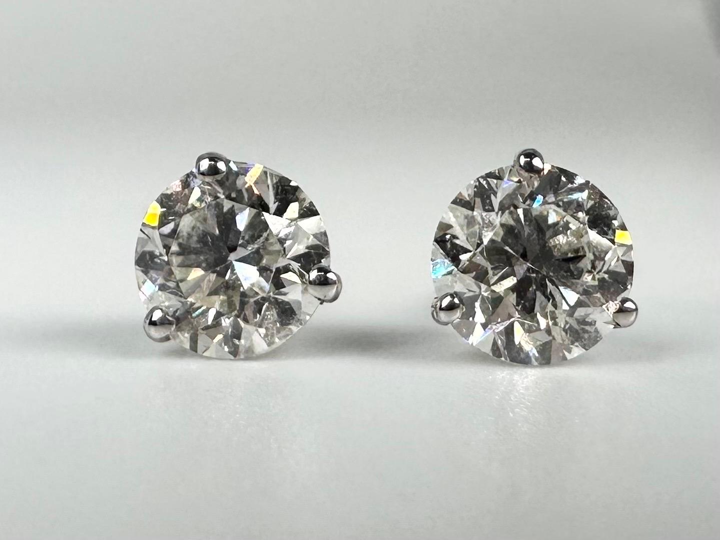 A pair of diamond stud earrings in 14KT white gold, martini 3 claw setting looks stunning and unusual when on ears.

GOLD: 14KT gold
NATURAL DIAMOND(S)
Clarity/Color: SI/F-G
Carat:1.98ct
Cut:Round Brilliant
Grams:1.5
Item: 15000034krfm

WHAT YOU GET