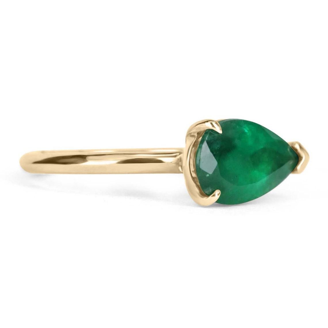 This ring is not for the faint of heart! Displayed is a rich dark green earth mined emerald, teardrop solitaire ring set east to west in 14K gold. This gorgeous solitaire ring carries a full 2.0-carat emerald that has incredible flaws that will have