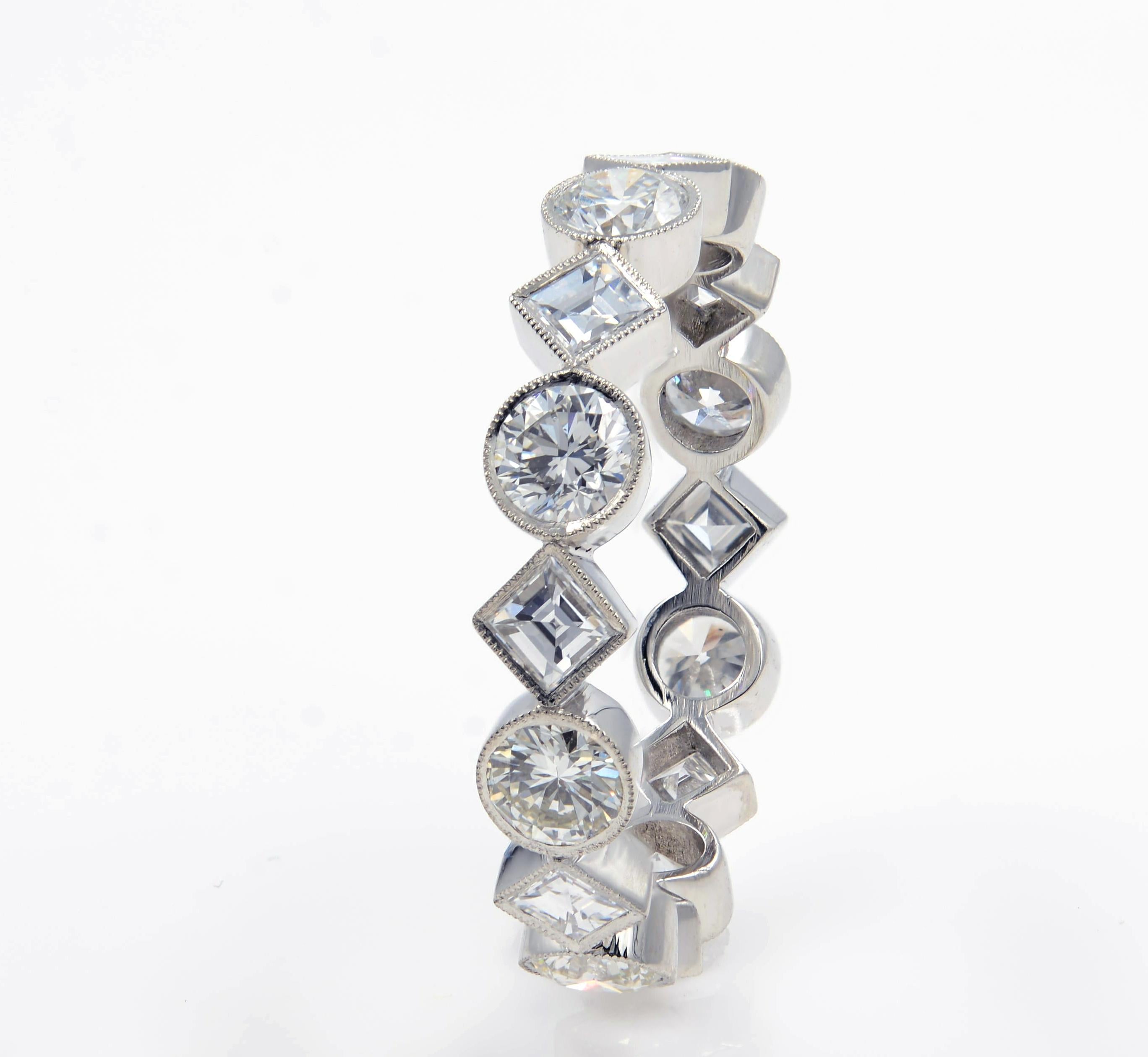 Just under 2.00 carats of glittering carre cut and round diamonds are set into this desirable and unique slim eternity band. The diamonds are set snugly in a bezel finished with fine milgrain details and a beautiful open under gallery. This band is
