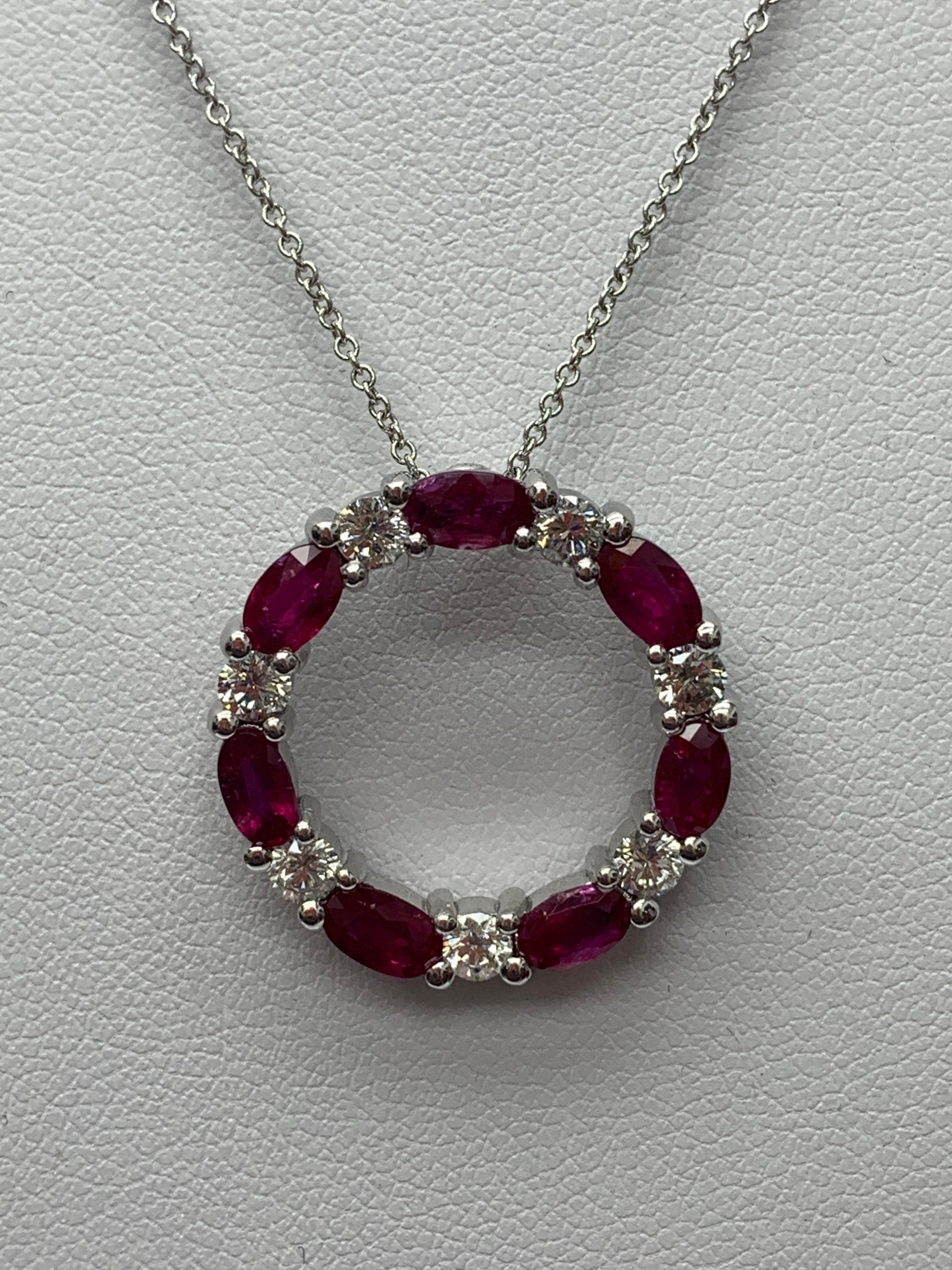 Un collier pendentif élégant mettant en valeur une rangée de rubis alternant avec des diamants, sertis dans un design circulaire ajouré. 7 rubis de forme ovale pèsent 1.99 carats et 7 diamants taille brillant pèsent 0.71 carats au total. Tous les