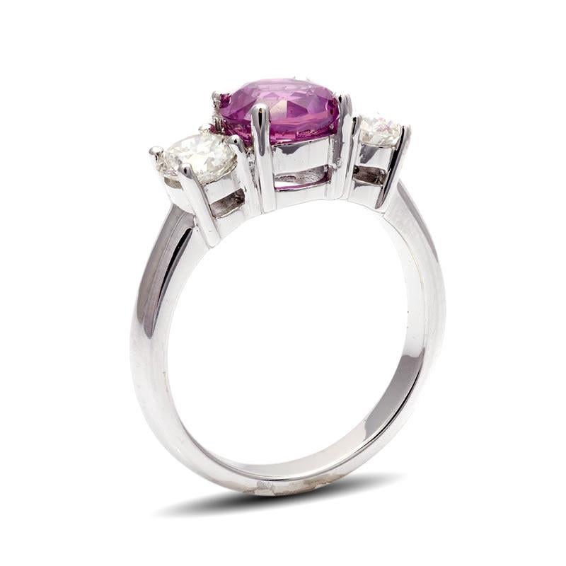 This Classic Three-Stone Pink Sapphire Ring is a captivating beauty that transcends price considerations. With 1.99 carats Pink Sapphire, set in 18K White Gold, its distinct charm is undeniable. The ring's allure is so compelling that it