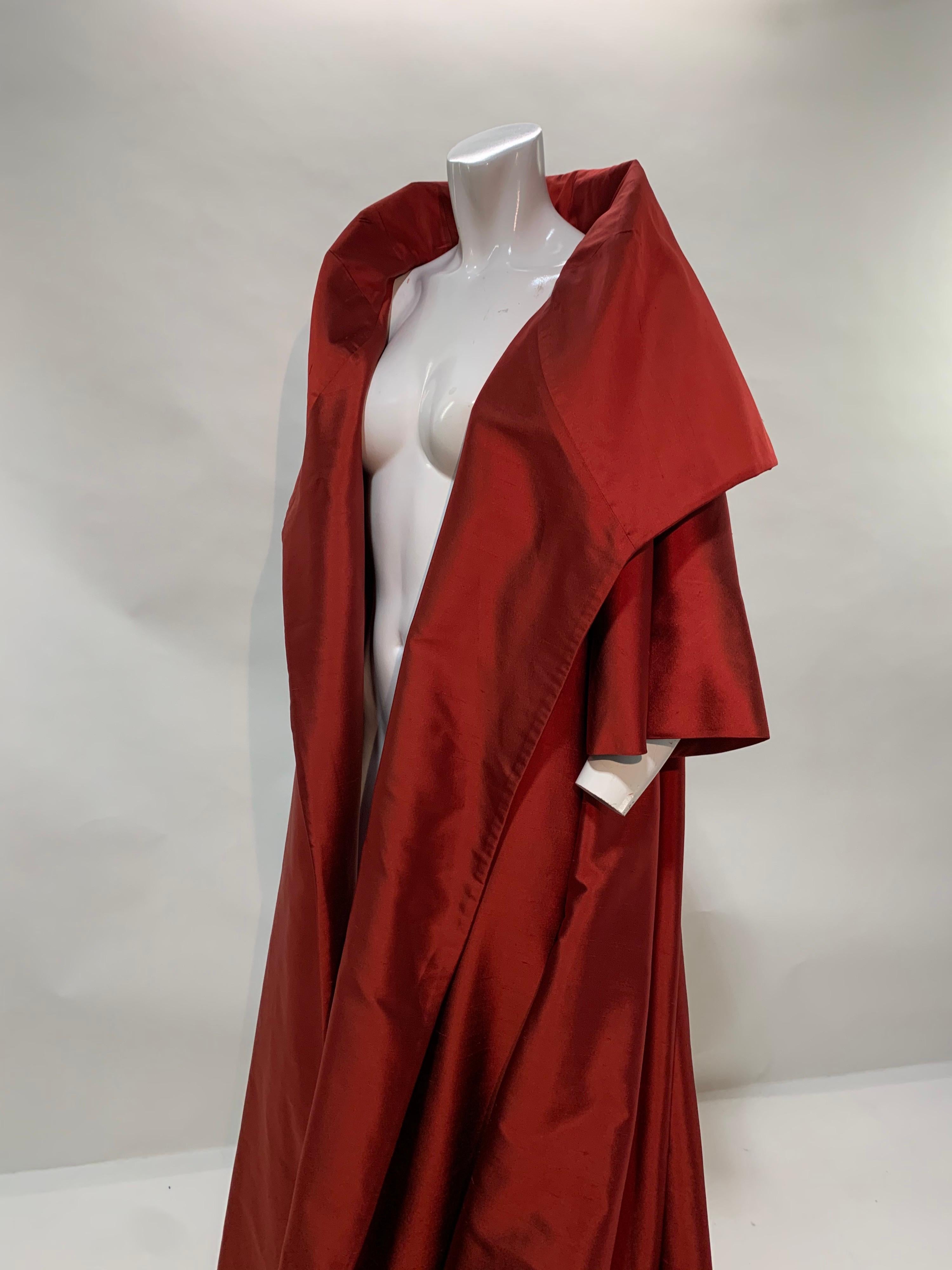 A fabulous Christian Dior by Gianfranco Ferre voluminous red changeant silk taffeta opera coat with dramatic shawl collar and train. An elegant double layered design is finished inside and out with additional stays in collar for structure. From the