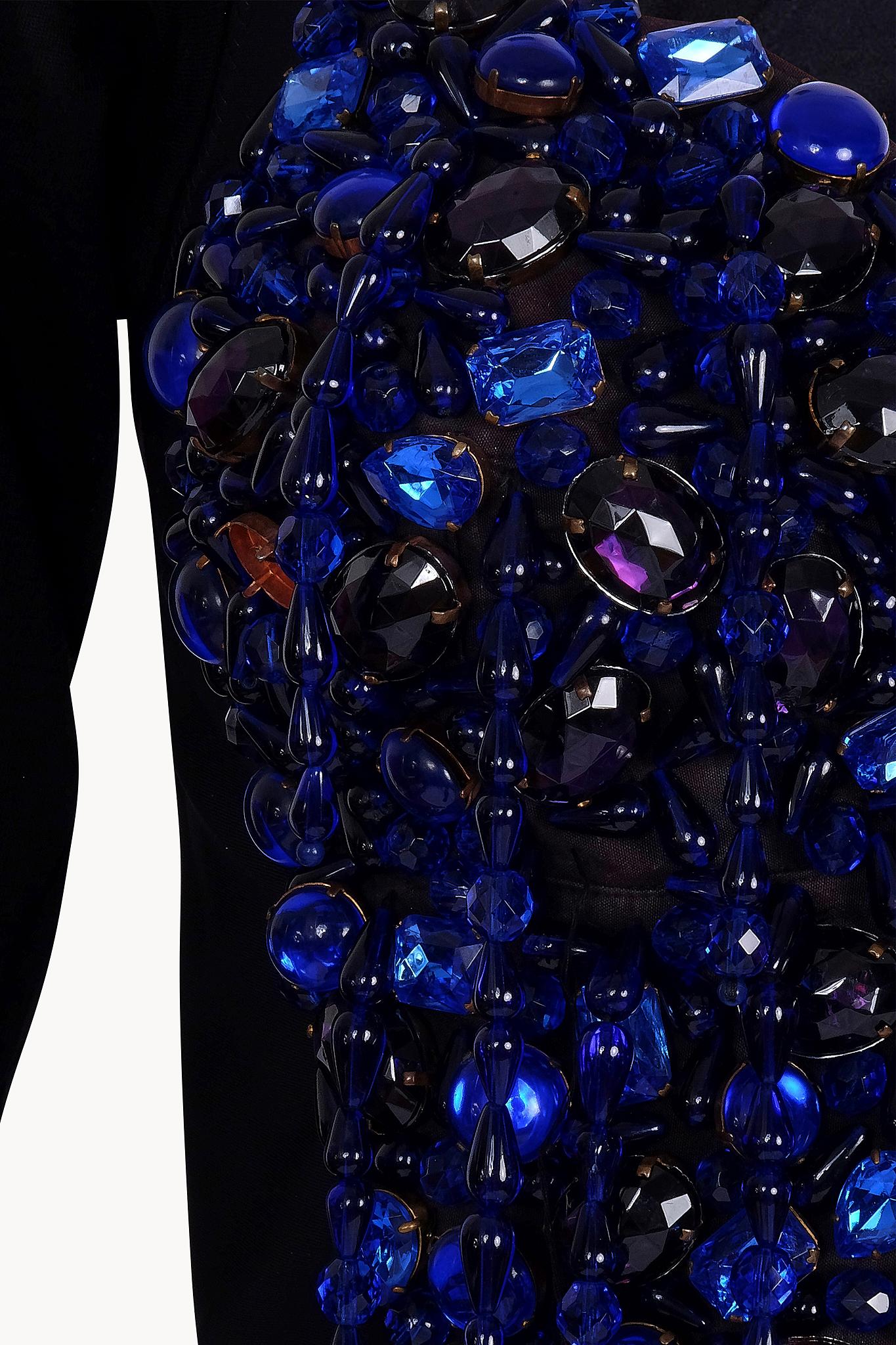 Incredible and one of a kind 1990 Dolce & Gabbana corset adorned in blue stones and fringes. Features deep cleavage, long sleeve and a blue silk georgette cape.