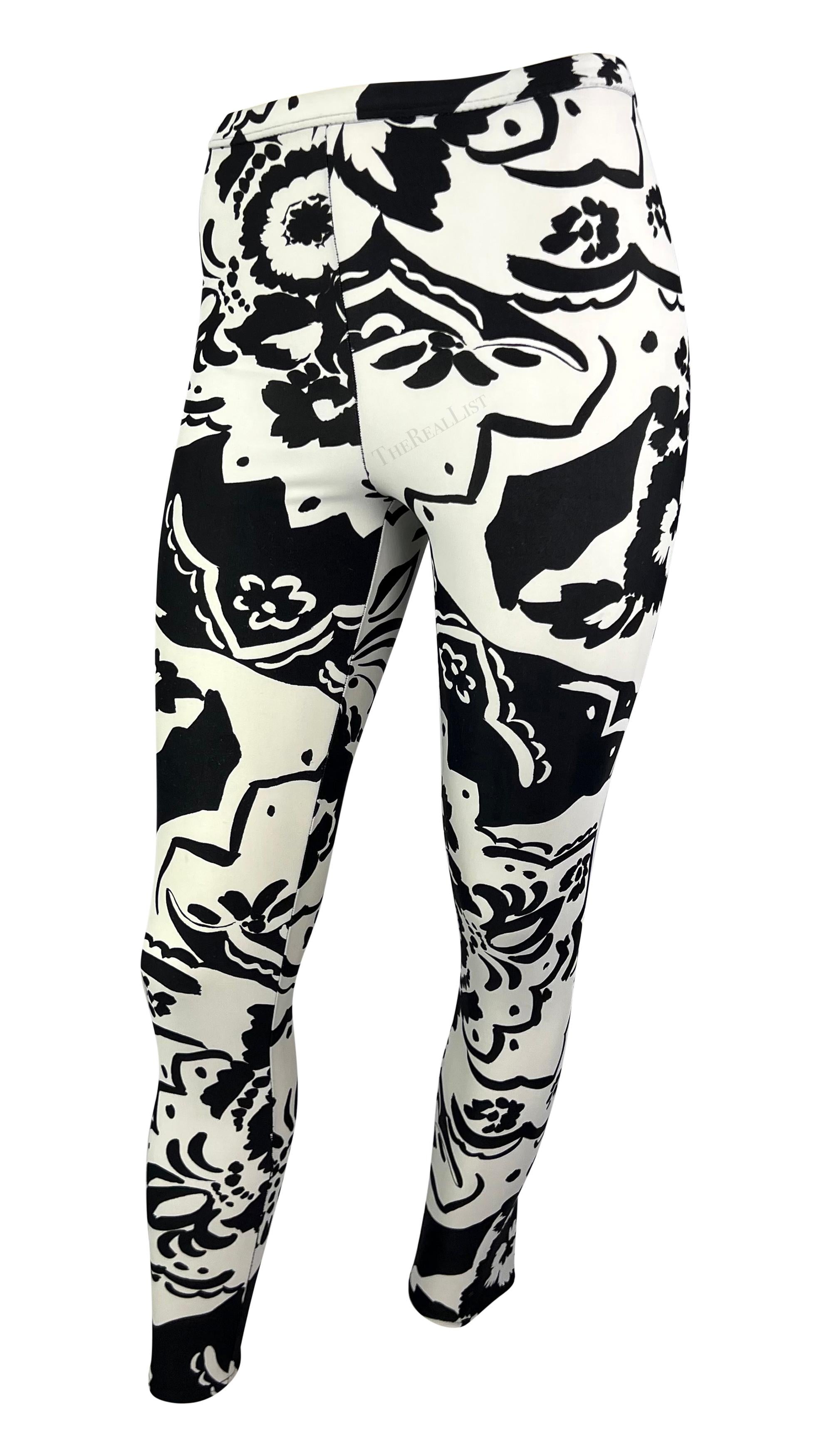 Presenting a pair of black and white floral Gianni Versace tights, designed by Gianni Versace. From 1990, these stretch leggings are covered in a bold abstract floral pattern and feature a high waist. 

Approximate measurements:
Size - IT42
Waist: