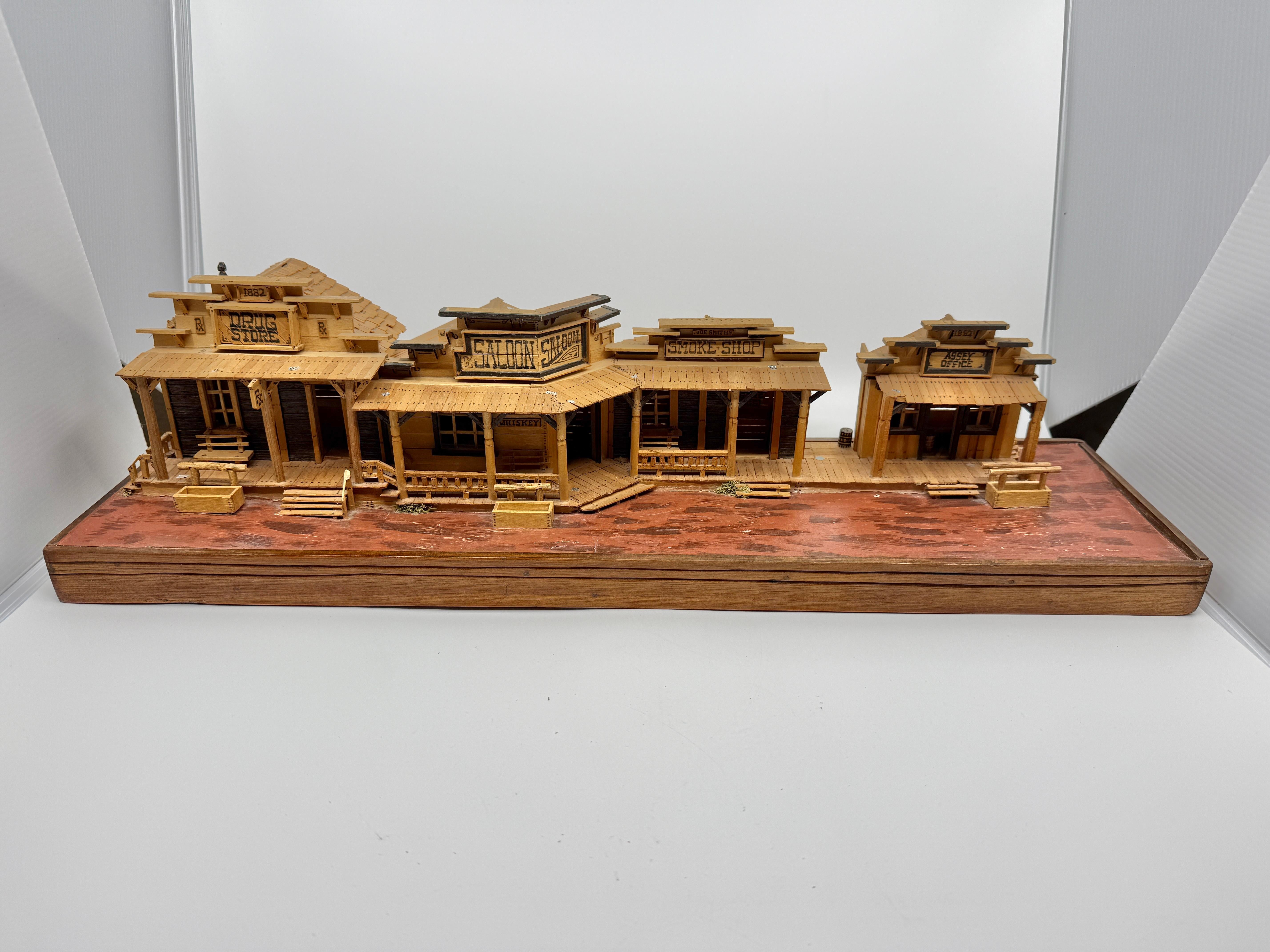 Un modello meravigliosamente dettagliato e realizzato a mano di una vecchia città del selvaggio West. Dispone di un saloon, di un ufficio postale, di un negozio di medicinali e di una fumeria. Modellato con cura e piuttosto intricato. È firmata sul