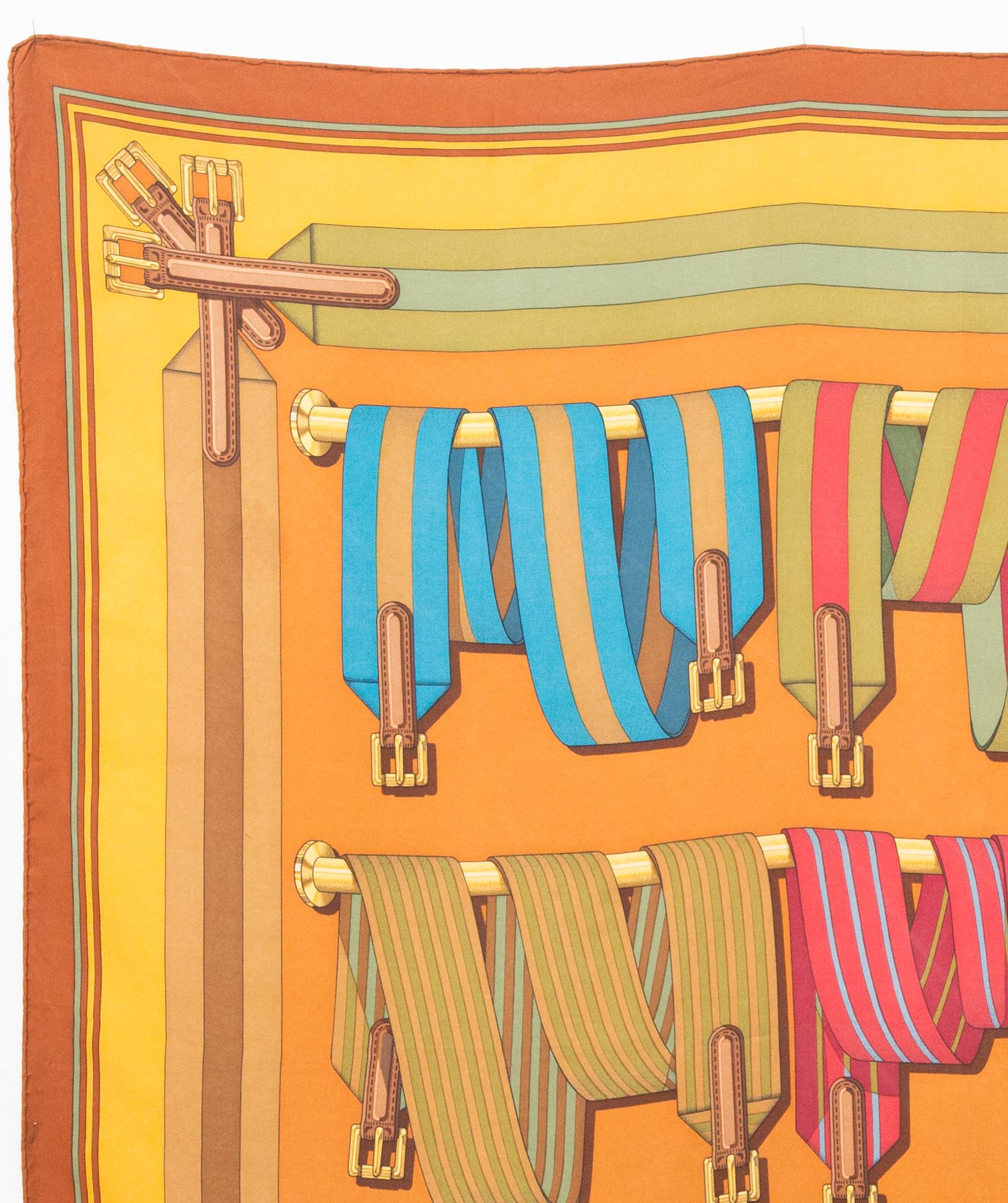 Foulard en soie Hermès Les Sangles by J.Metz présentant une bordure ocre, une signature logo.
Circa 1990
En bon état vintage. Fabriqué en France.
35,4in. (90cm)  X 35,4in. (90cm)
Nous vous garantissons que vous recevrez  article iconique tel que