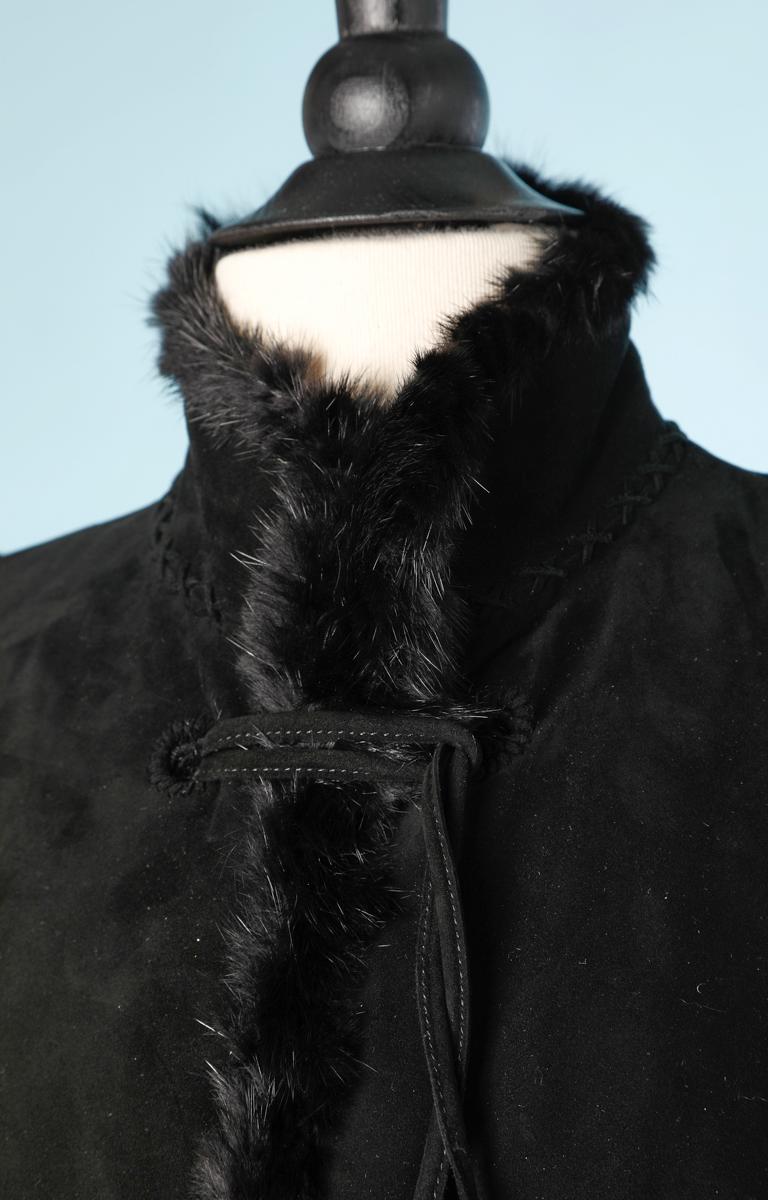 1990 jacket in suede and black fur from Yves Saint Laurent, with shoulder pads, long sleeves, waist marked by a fake embroidered belt, attaches at the front with ties slid into embroidered eyelets in trimmings with tassels, back marked by two X