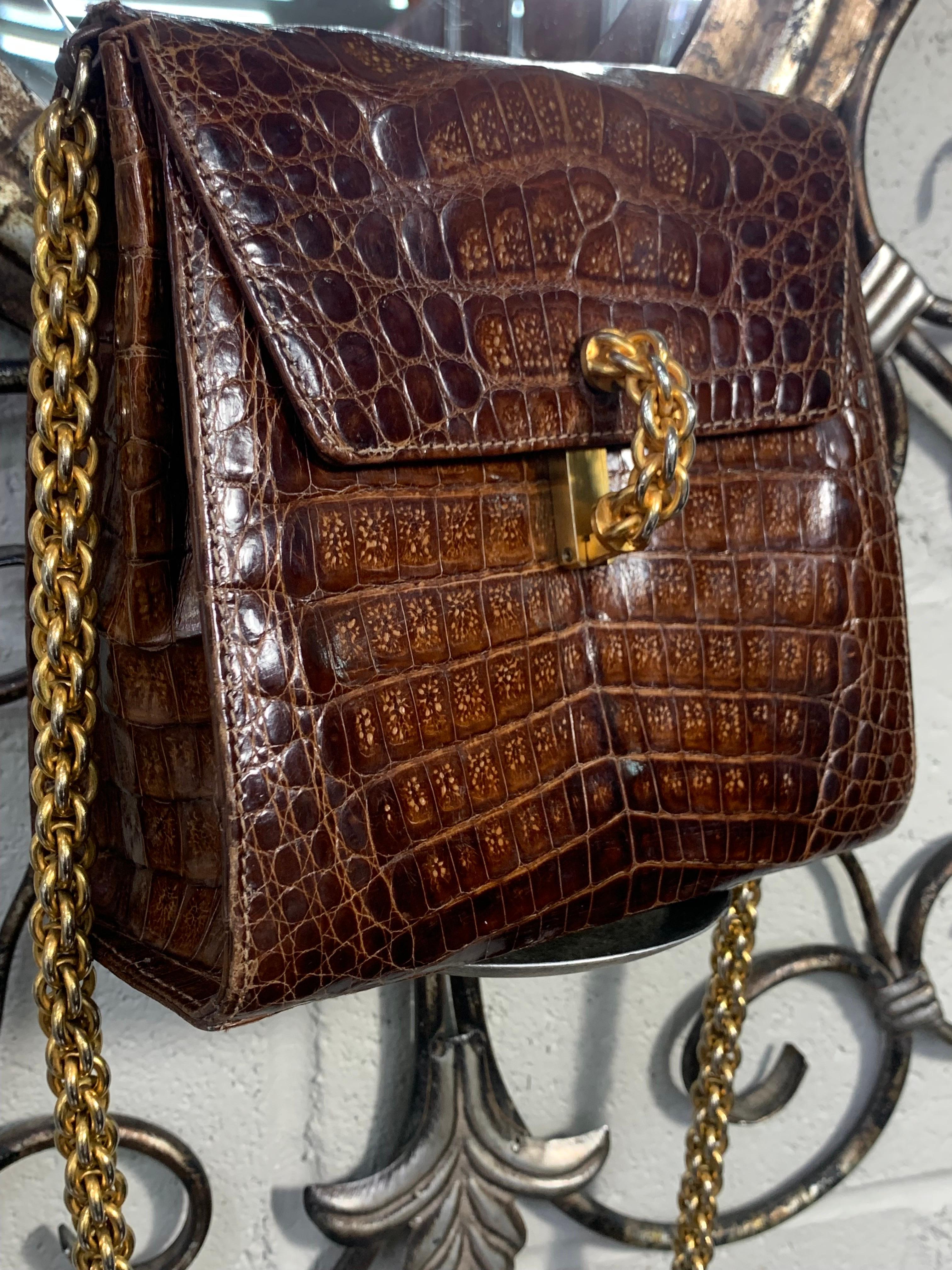 A fabulous 1990s Paloma Picasso medium brown alligator structured shoulder bag with front flap closure. Clasp and shoulder strap are in a gold-tone heavy rope link chain. Interior is in excellent condition. 