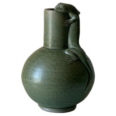 An olive green pottery bud base with lizard motif