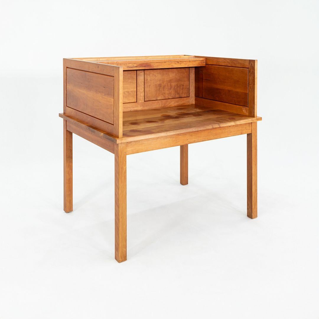 Questo è uno scrittoio da biblioteca, disegnato da Thomas Moser e prodotto da Thos. Moser Cabinetmakers con sede a Auburn, nel Maine. Questo pezzo risale al 1990. Questa scrivania è realizzata in legno di ciliegio ed è divisa in due
