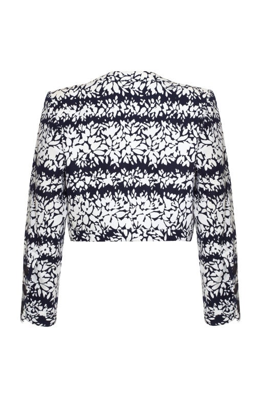This stylish Spring 1990 Yves Saint Laurent cropped bolero jacket is a wonderfully diverse piece and of excellent quality. The jacket  is comprised of heavy duty cotton fabric and features an abstracted floral print in deep navy and white with 3 x