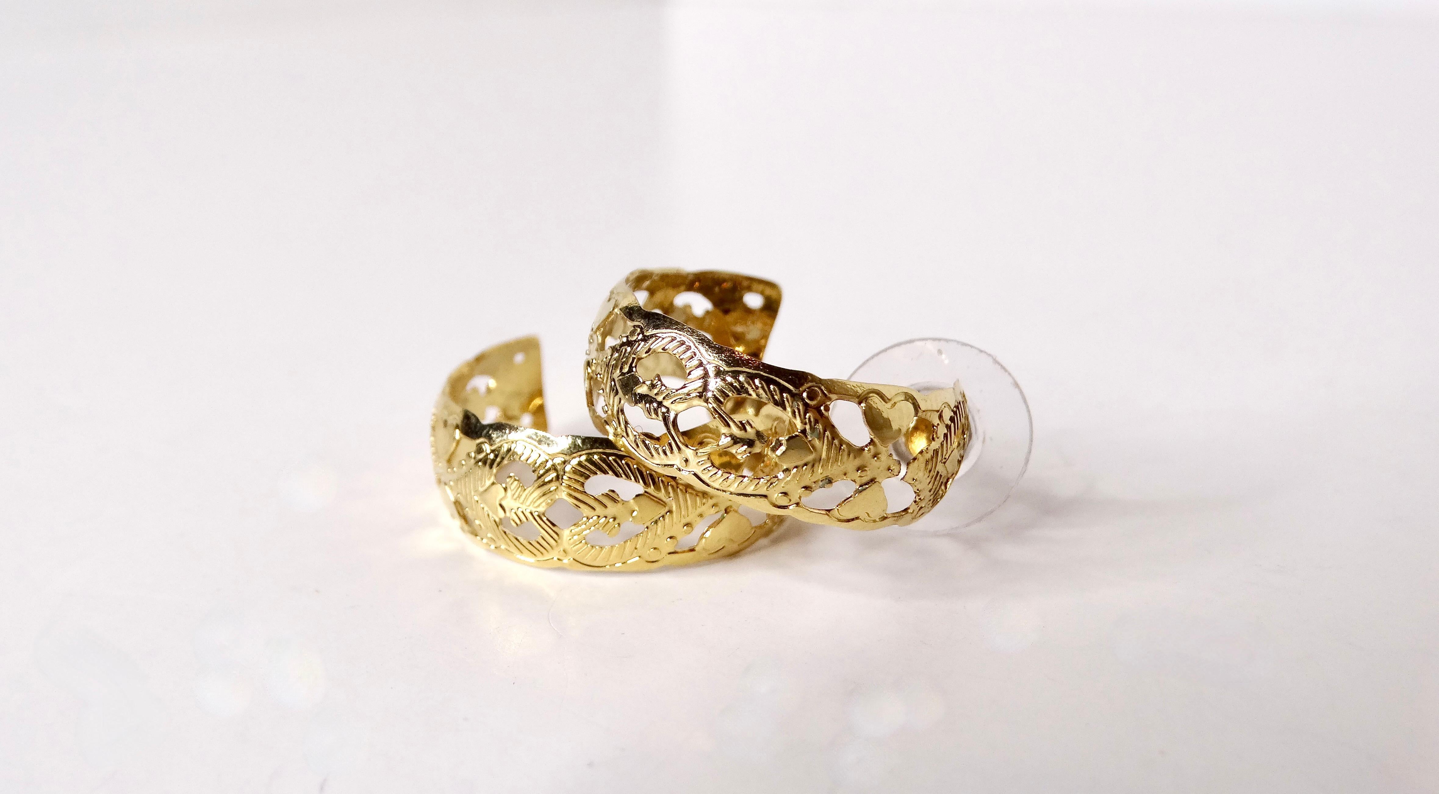Ti presentiamo i nostri squisiti orecchini a cerchio stile Anuhea con cuore inciso degli anni '90 placcati in oro 14k: una splendida incarnazione dell'eleganza retrò e della giocosa raffinatezza. Realizzati con un'attenzione meticolosa ai dettagli,