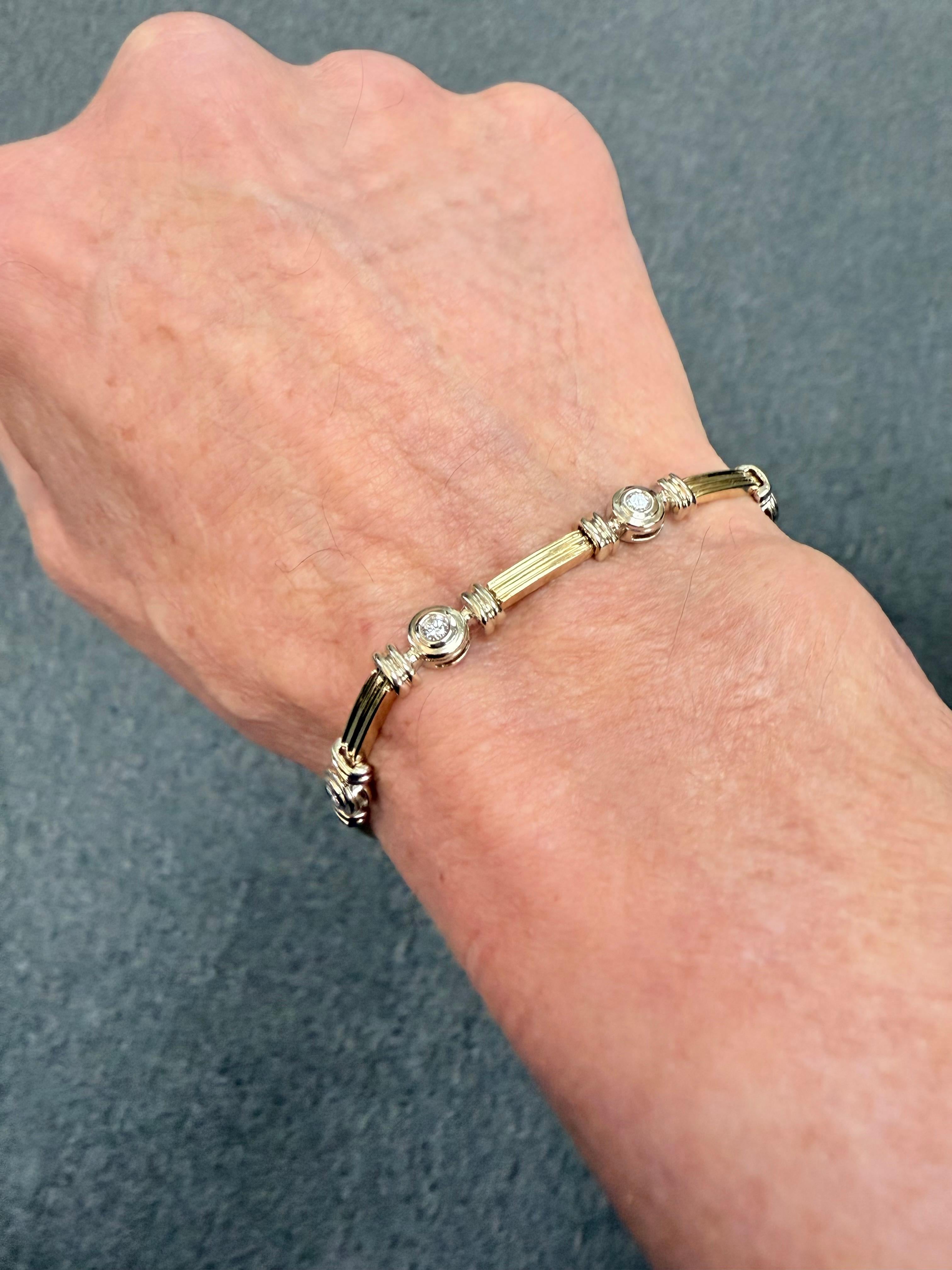 
1990er Jahre 14k zweifarbiges Diamantarmband.

Dieses 14-karätige zweifarbige Armband mit Diamanten wurde in den 1990er Jahren hergestellt.   Die Diamanten sind in runde Weißgoldabschnitte gefasst, gefolgt von schmalen gerippten Gelb- und