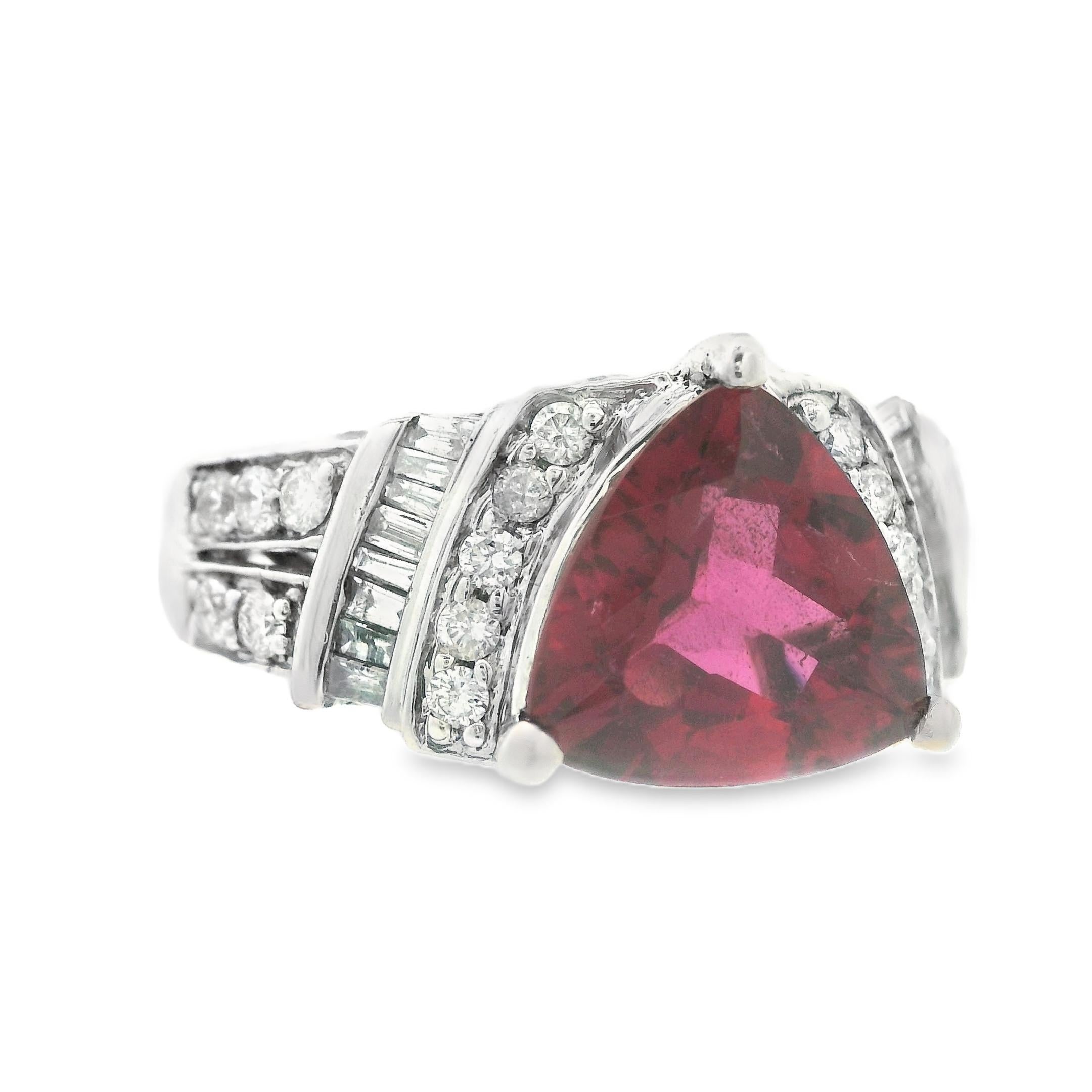 This beautiful natural triangular cut tourmaline ring from the 1990's is made in 14k white gold with round and baguette cut diamonds. The centerstone of this ring is an exceptional 2 carat, brilliant triangle cut, natural red tourmaline. This ring