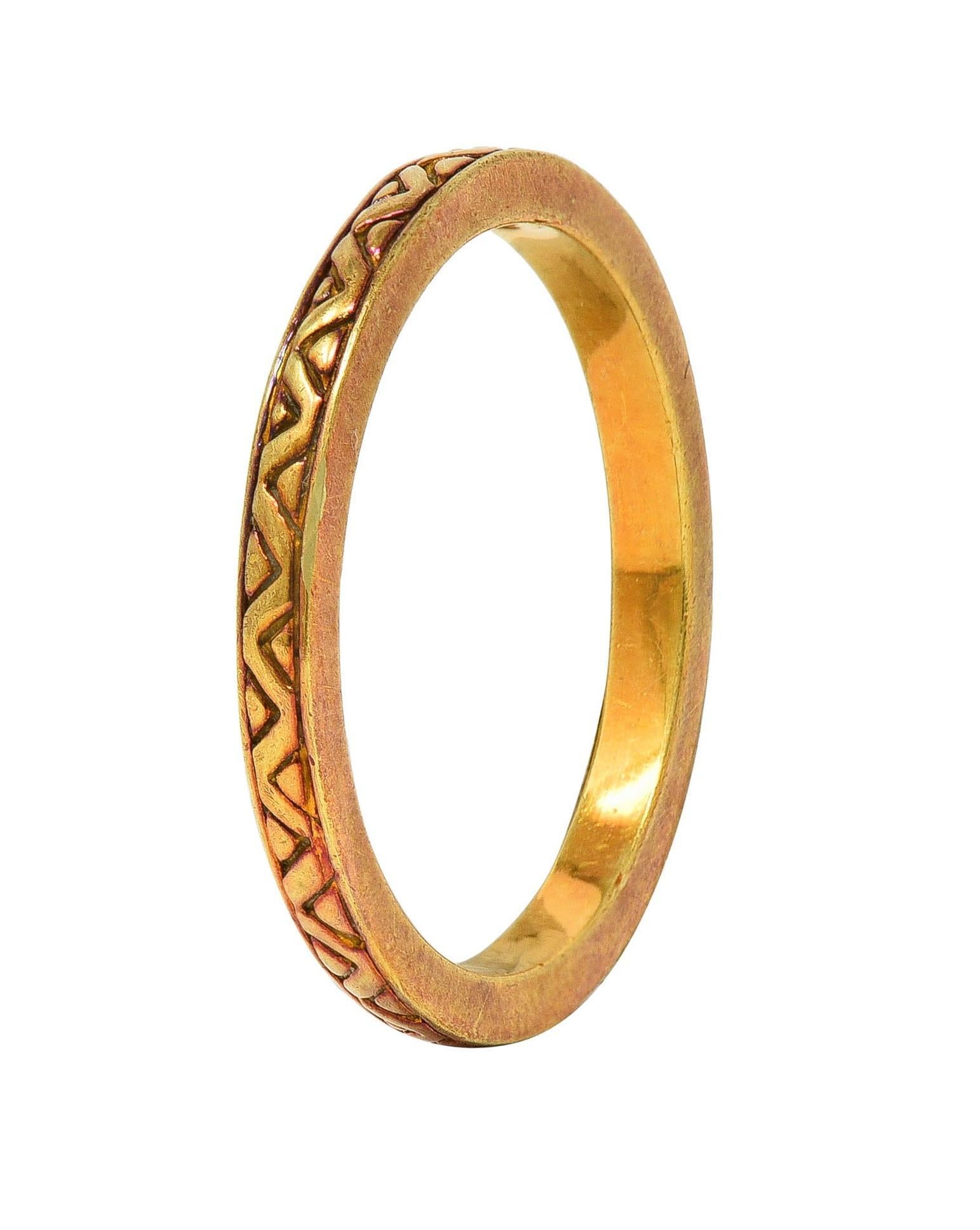 Designed as a gold band engraved fully around
Displaying a zig-zag motif pattern 
With subtle patina 
Stamped for 18 karat gold
With partial maker's mark
Circa: 1990s
Ring Size: 6 1/4 and not sizable
Measures north to south 2.0 mm and sits 2.0 mm